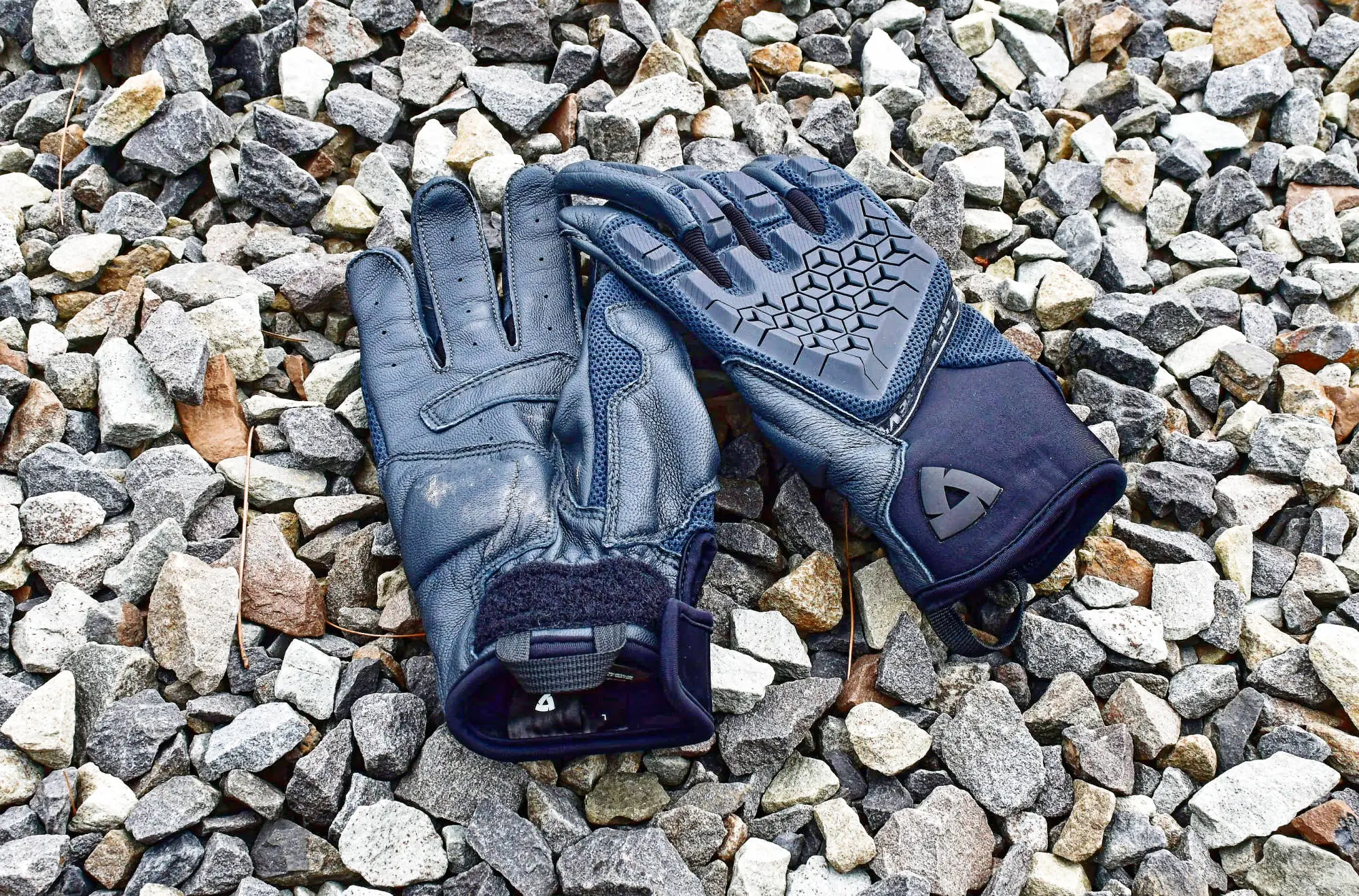 pair of rev’it sand 4 gloves laid out on small rocks