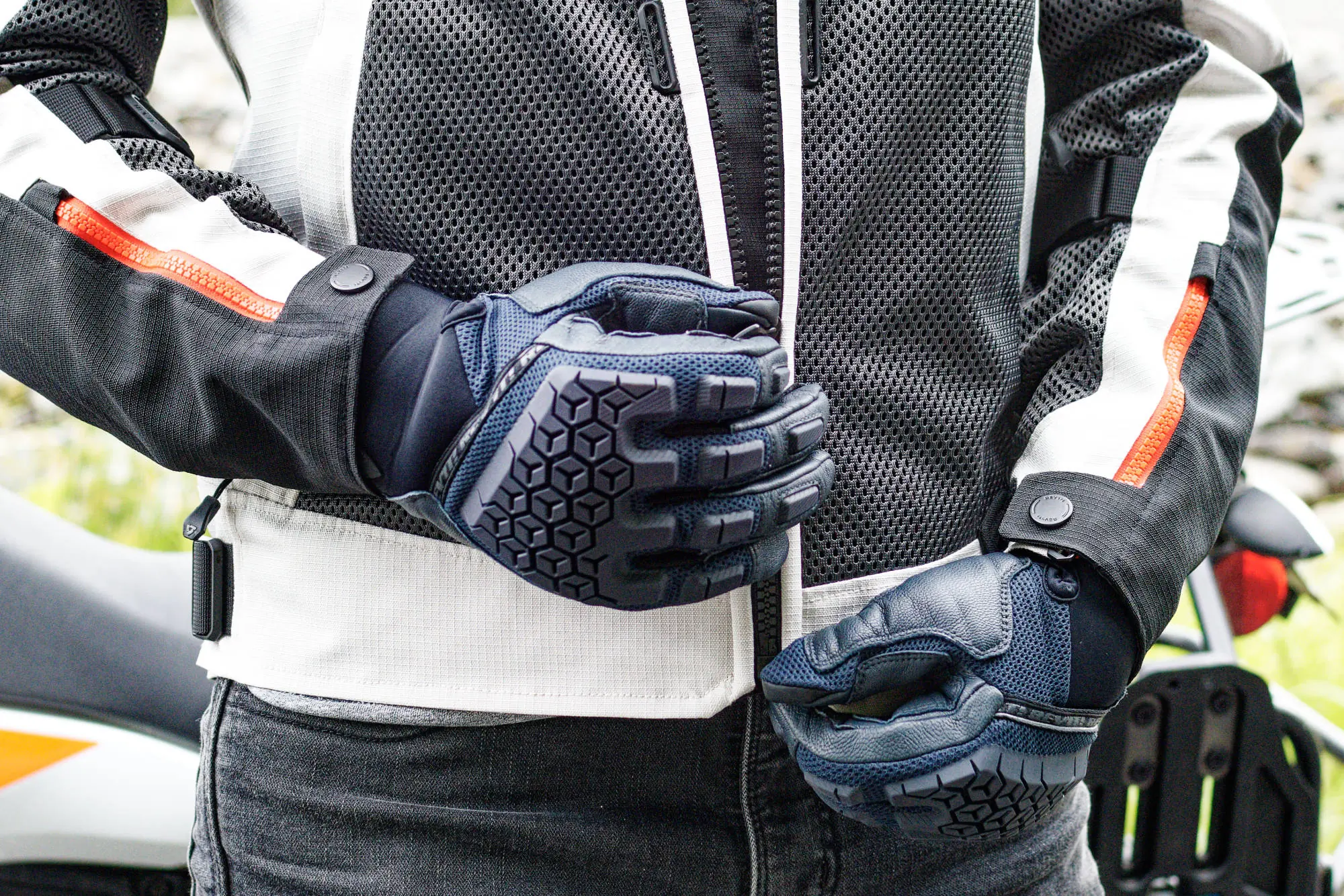 man zipping the jacket while wearing rev’it sand 4 gloves