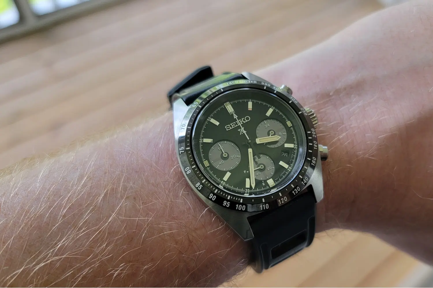 Seiko chronograph wristwatch with black dial and rubber strap on wrist