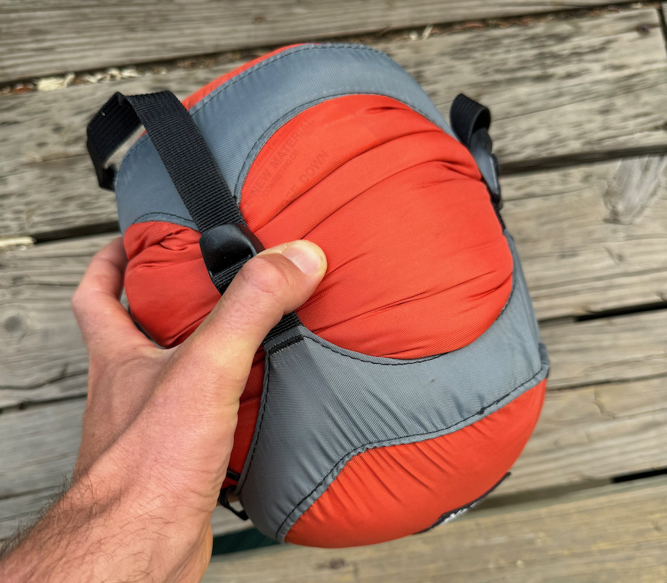 man holding packed western mountaineering alpinlite