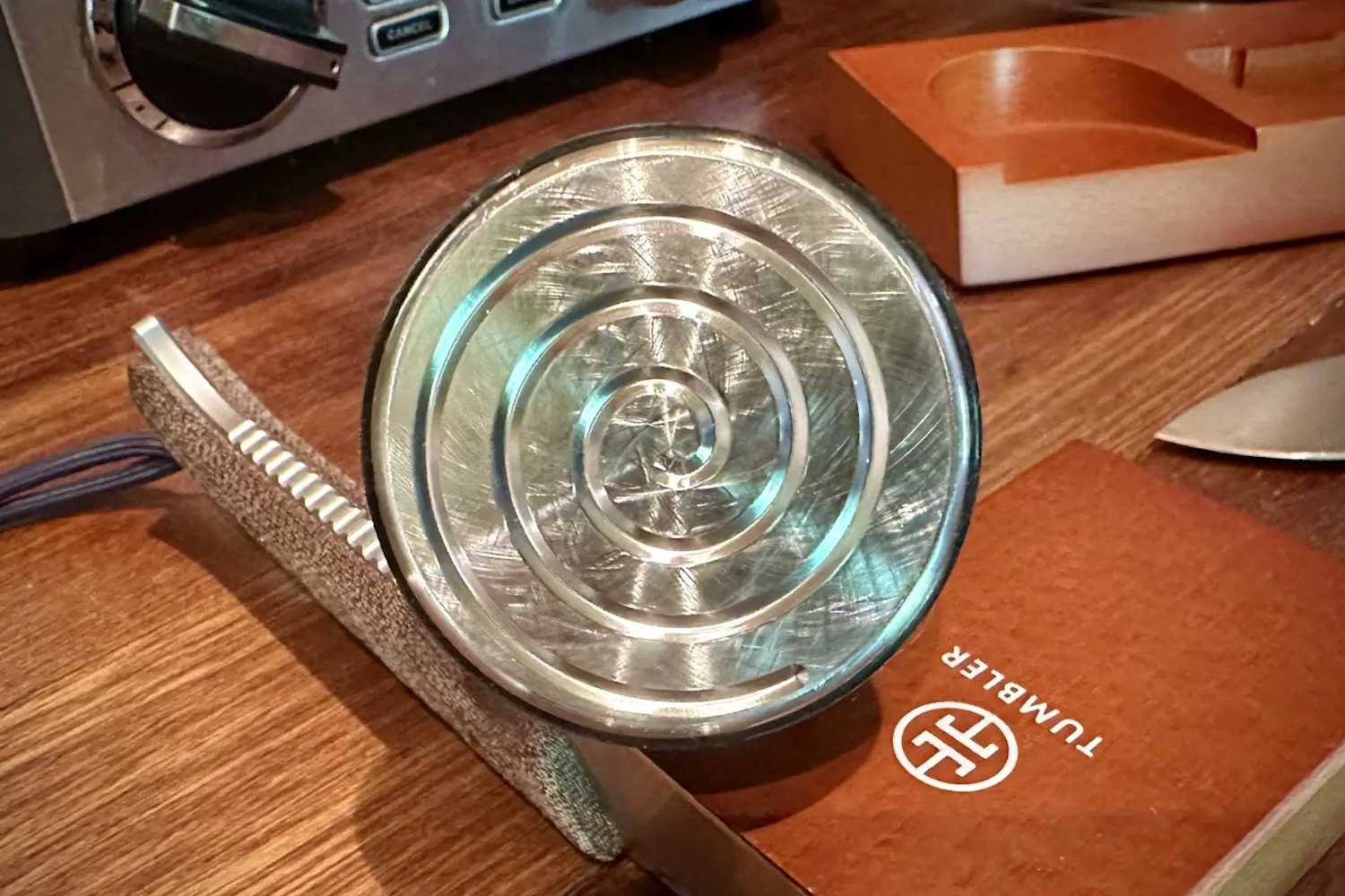 Close-up of a stainless steel helix-shaped tumbler on a wooden surface
