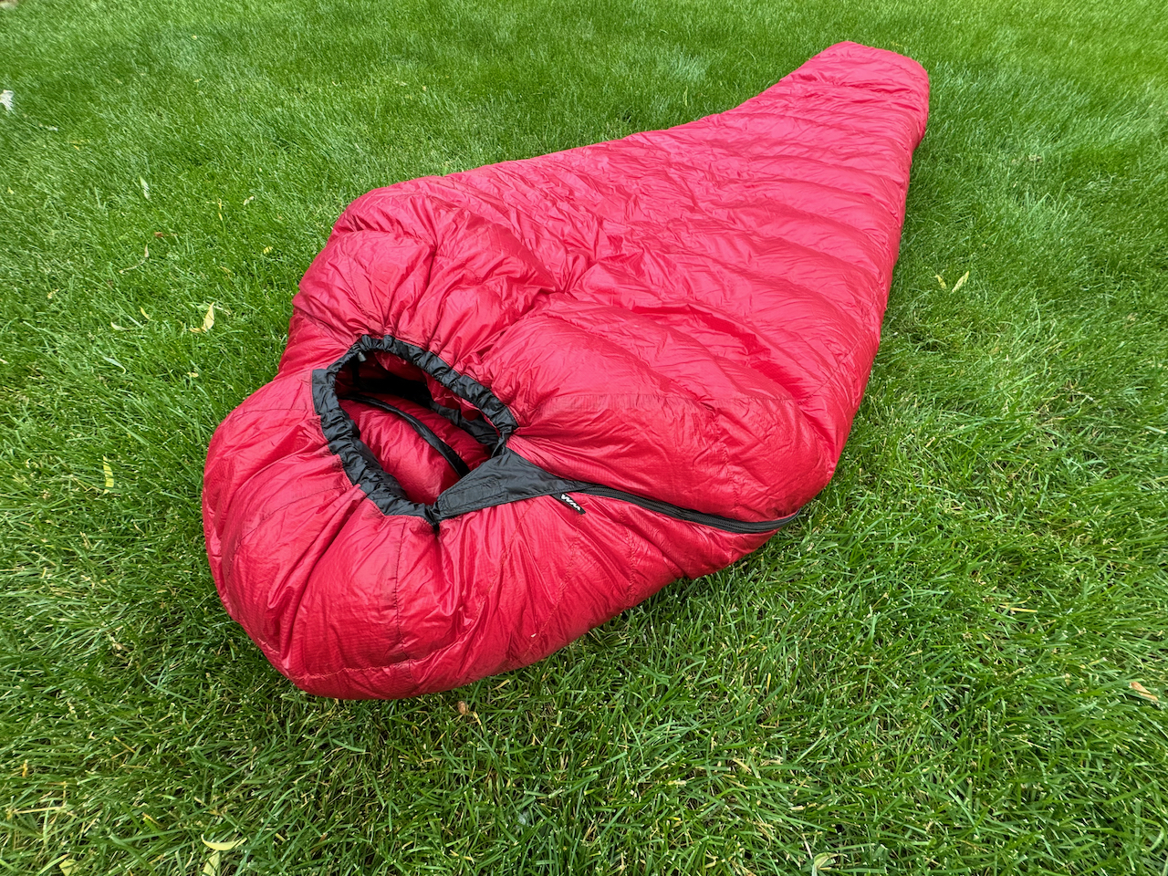 red western mountaineering alpinlite sleeping bag on the grass