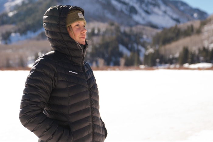 Women in a black Mammut jacket standing in a snowy landscape