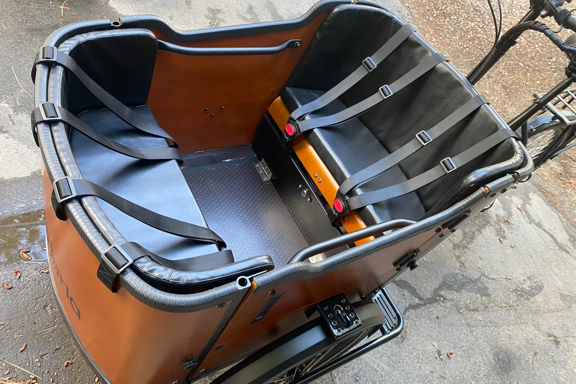 Looking at the front cargo box of the Ferla Royce 2 electric cargo bike, showing padded seats, for 3-point harnesses, and the non-slip floor