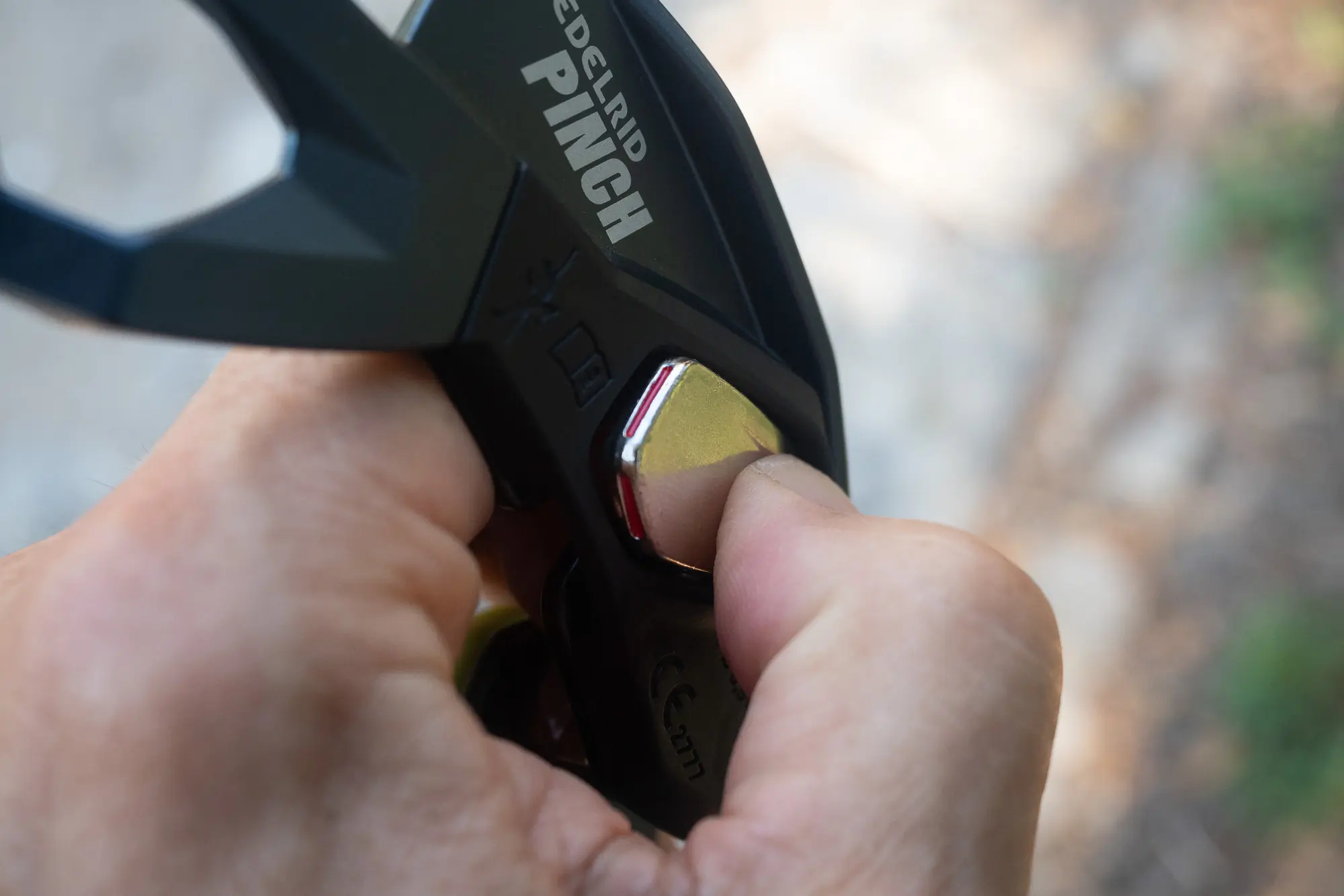 Detailed image of the side plate release button on the Edelrid Pinch