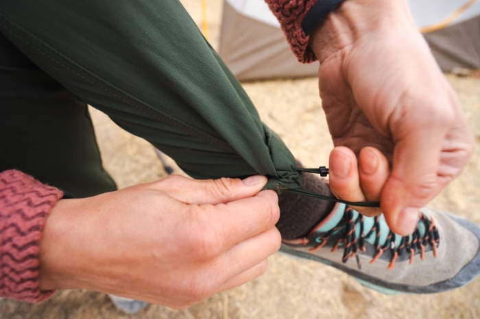 a close up of a woman's hands adjusting her outdoor research ferrosi pants