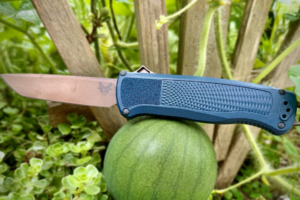 crater blue benchmade shootout otf knife balancing on a watermelon
