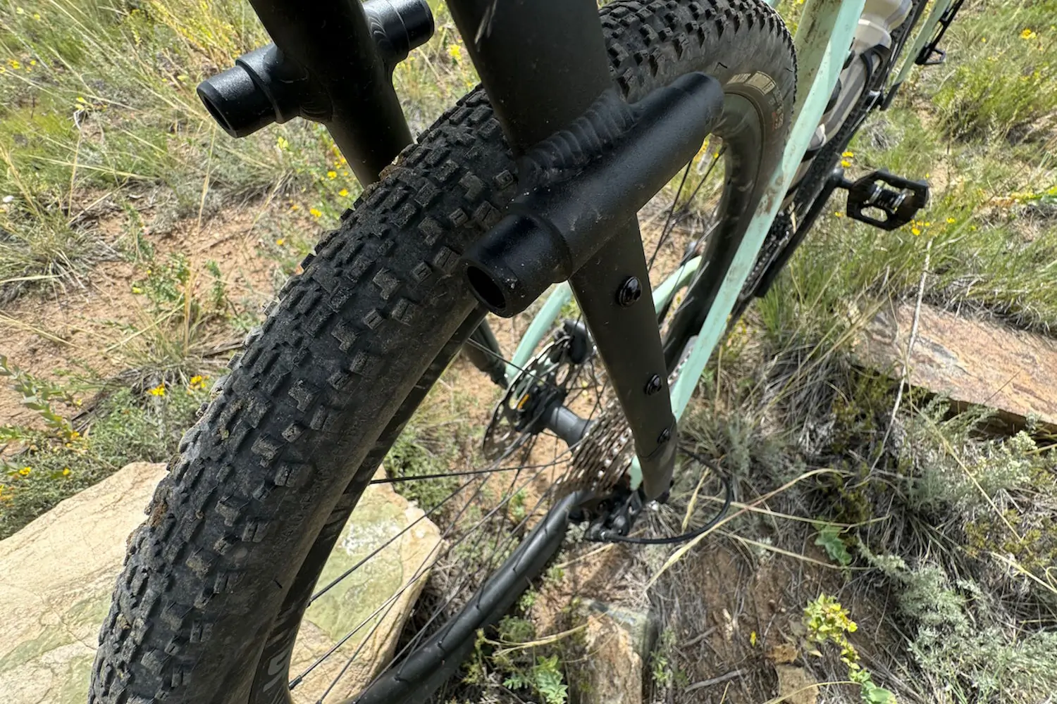 A close-up view of a gravel bike's wide tire with Tailfin Aeropack rack