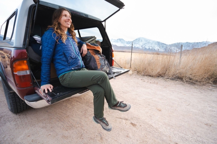 a woman is sitting in the trunk of a car parked outdoors. She is wearing outdoor research ferrosi pants