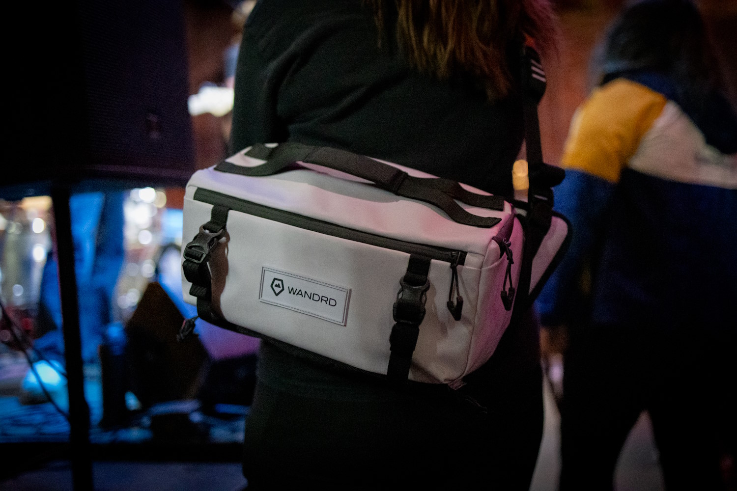 Person wearing WANDRD Rogue Sling camera bag at event