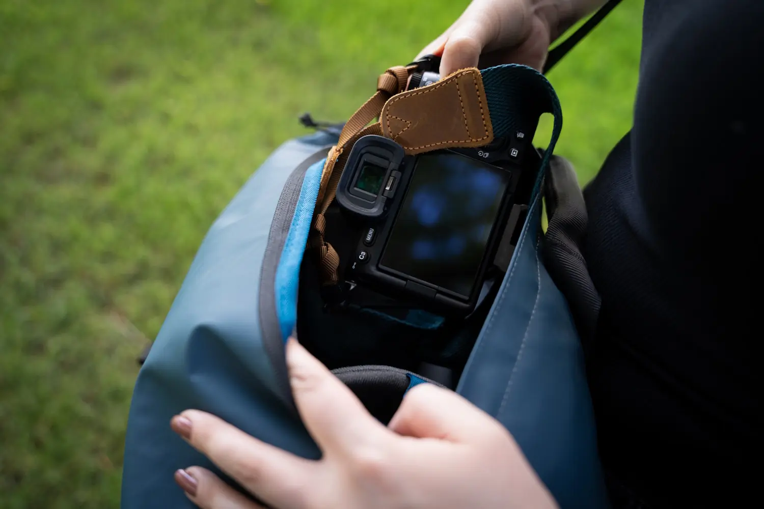 A person retrieving a camera from a Tenba DNA 16 Pro Messenger Bag