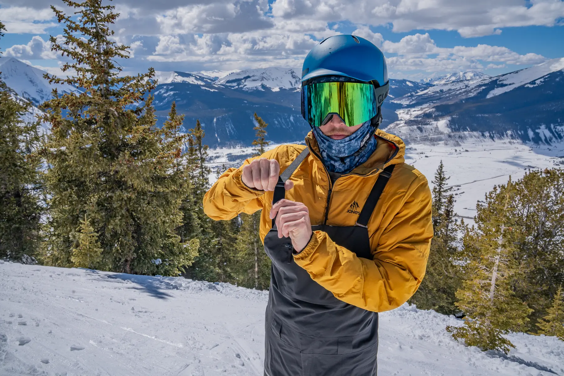 man adjusting elastic strap on ski bibs 
