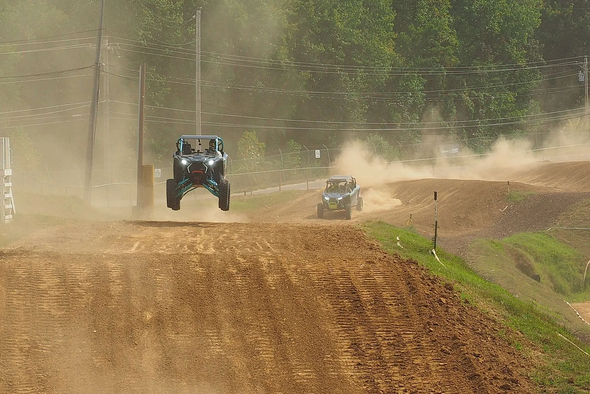 Two Polaris RZR Pro R vehicles racing on a dirt track