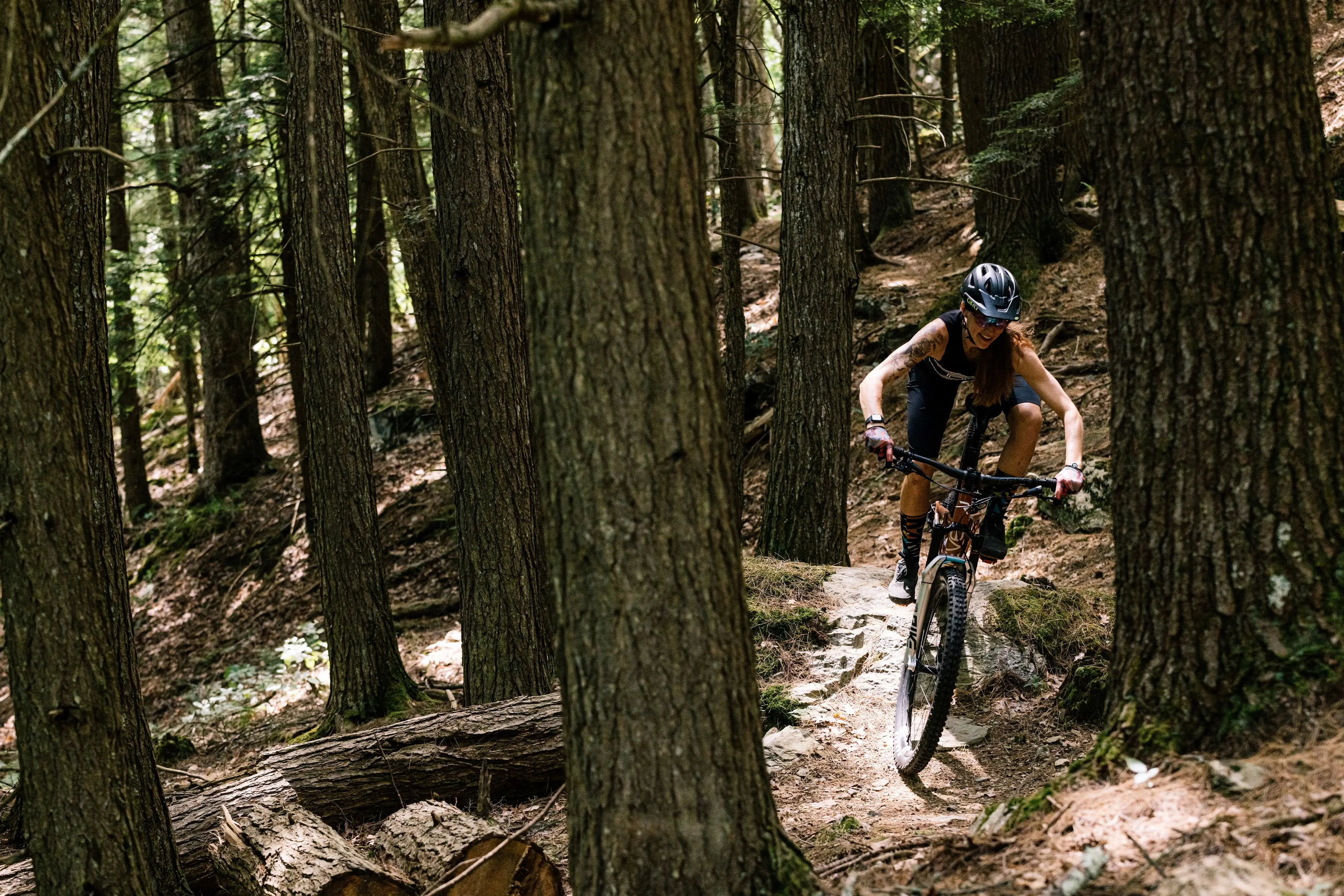 A mountain biker riding a trail in a wooded area.