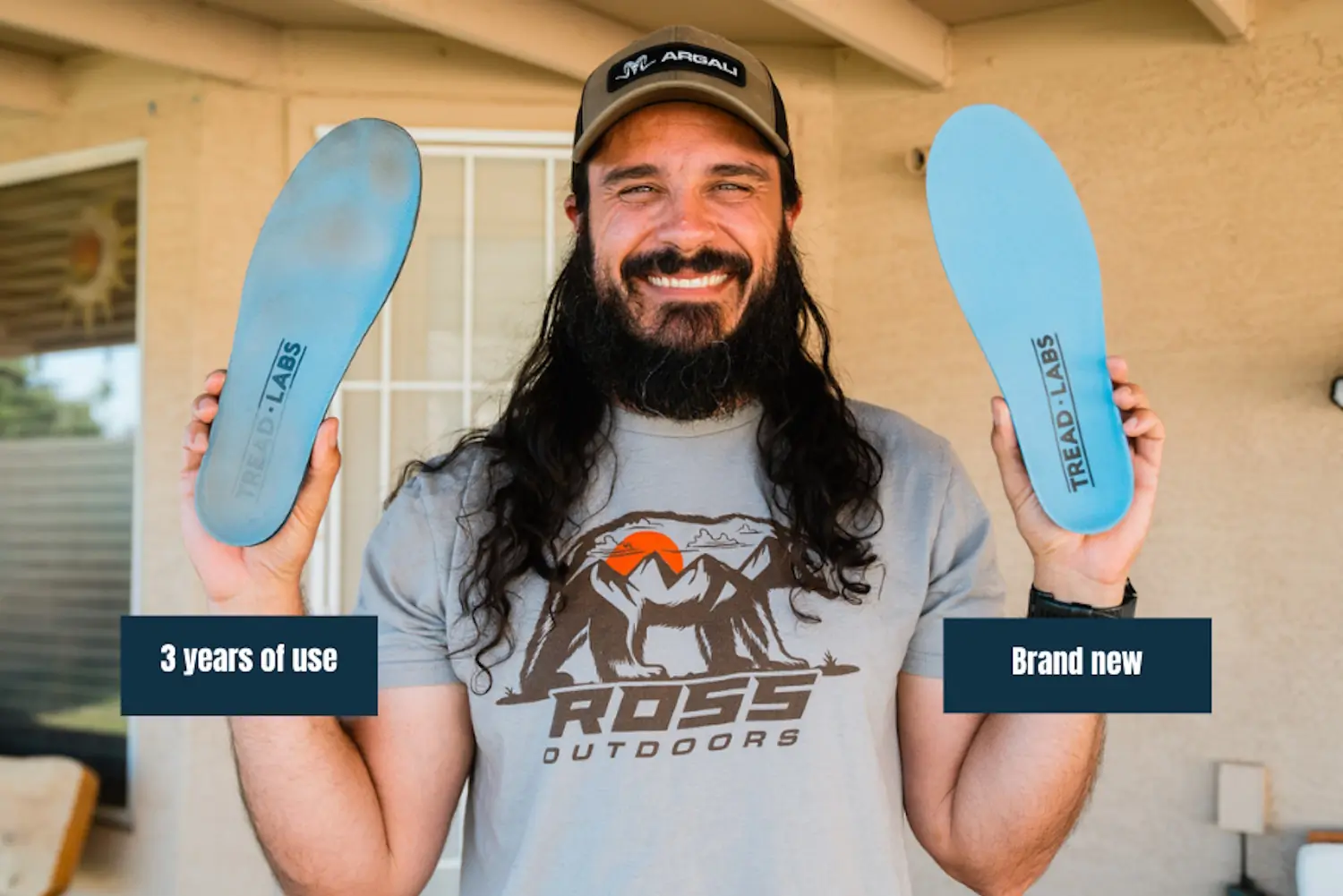 man holding two insoles from Tread Labs