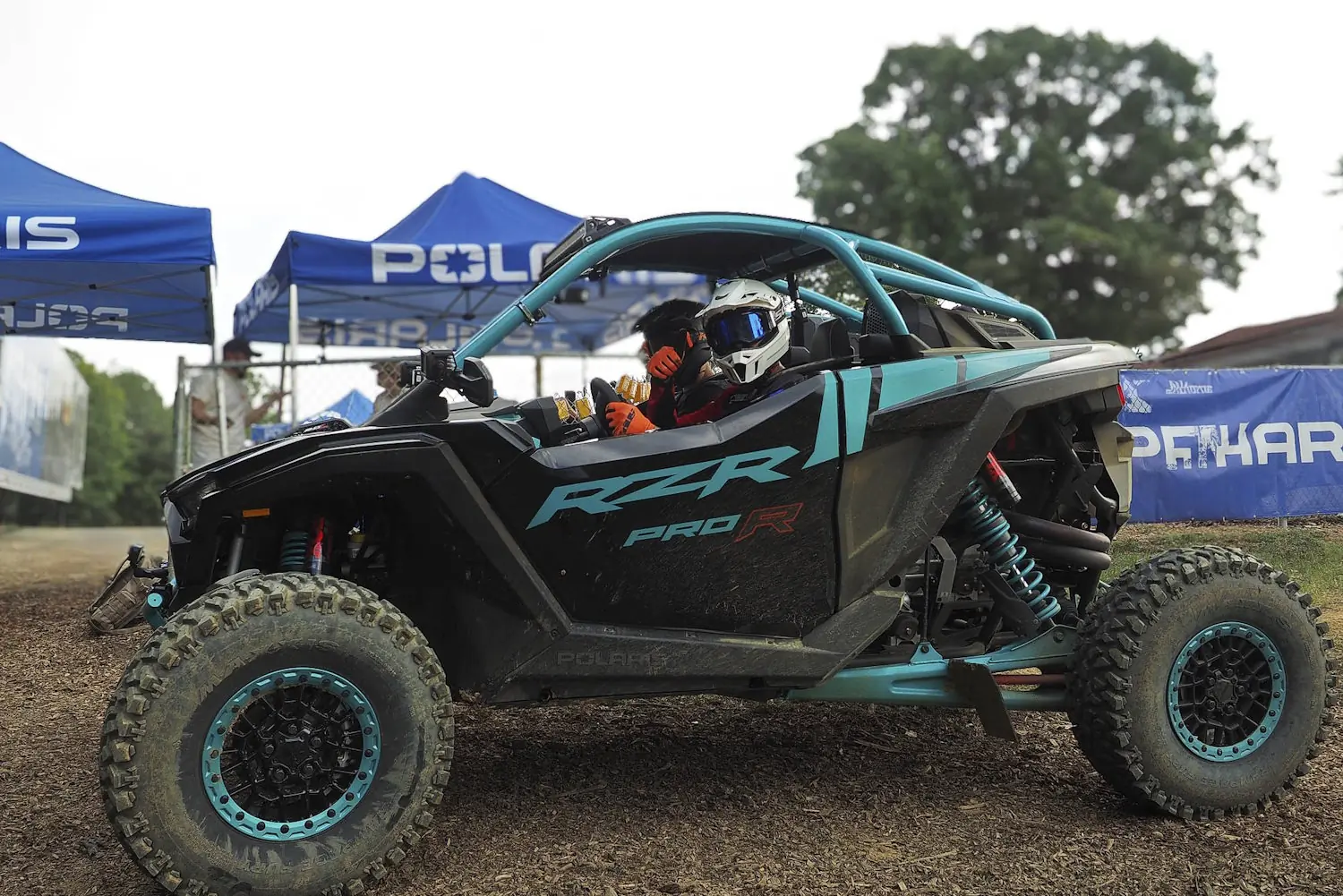 Person wearing helmet and gear sitting in a Polaris RZR Pro R off-road vehicle