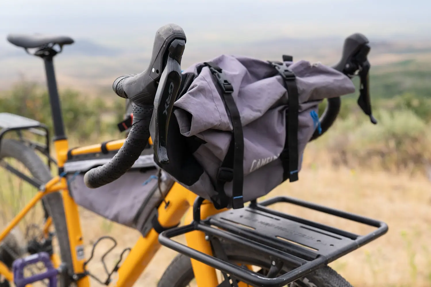 REI ADV 2.2 bike with a large grey handlebar bag