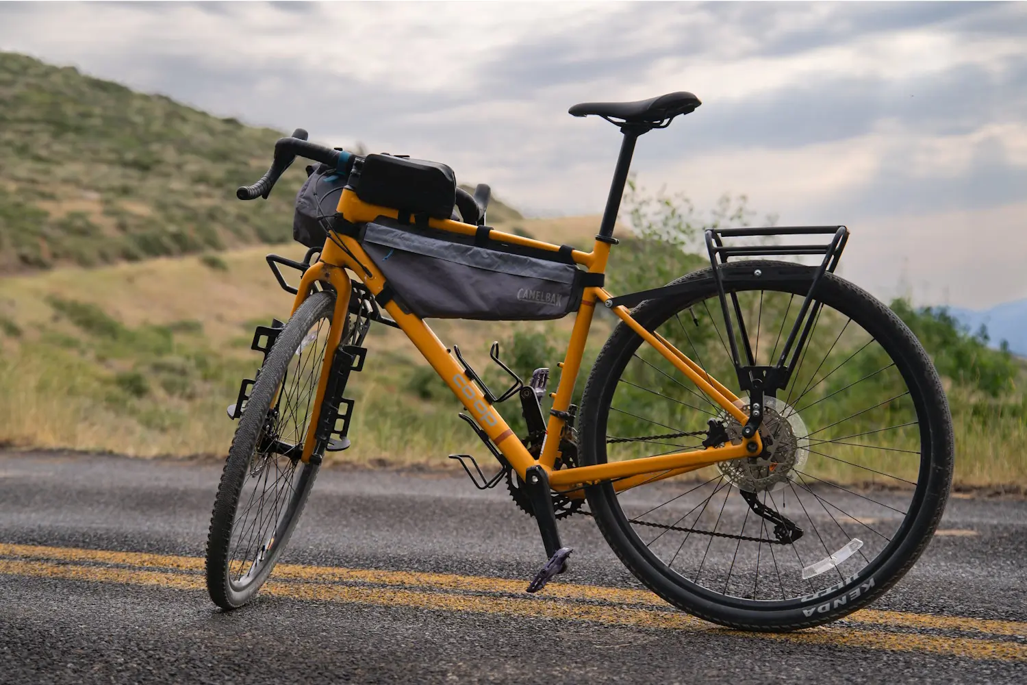 
A yellow REI Co-op ADV 2.2 bike with a frame bag and rear rack