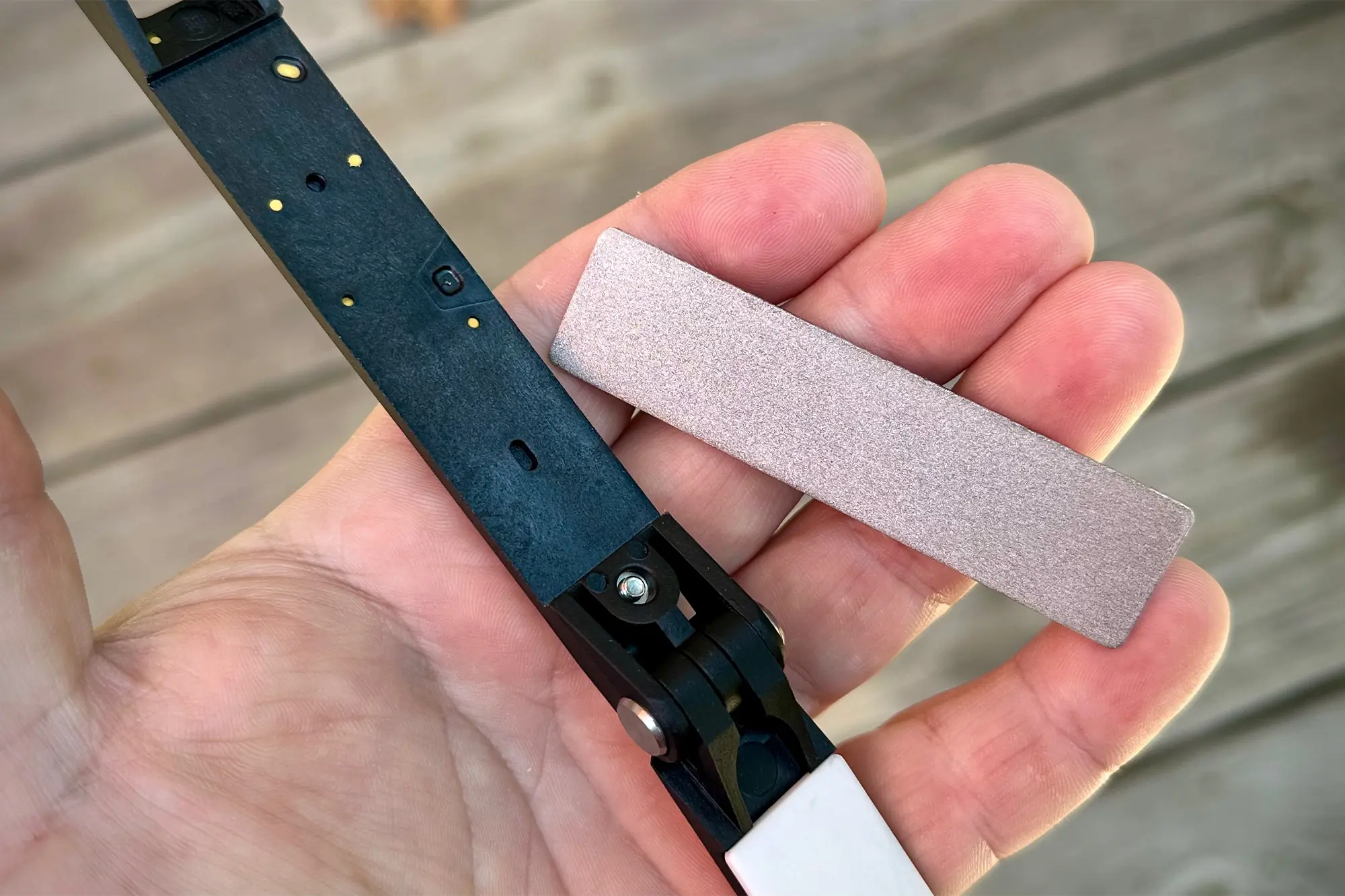 man hand in focus with sharpening plate detached from work sharp sharpener