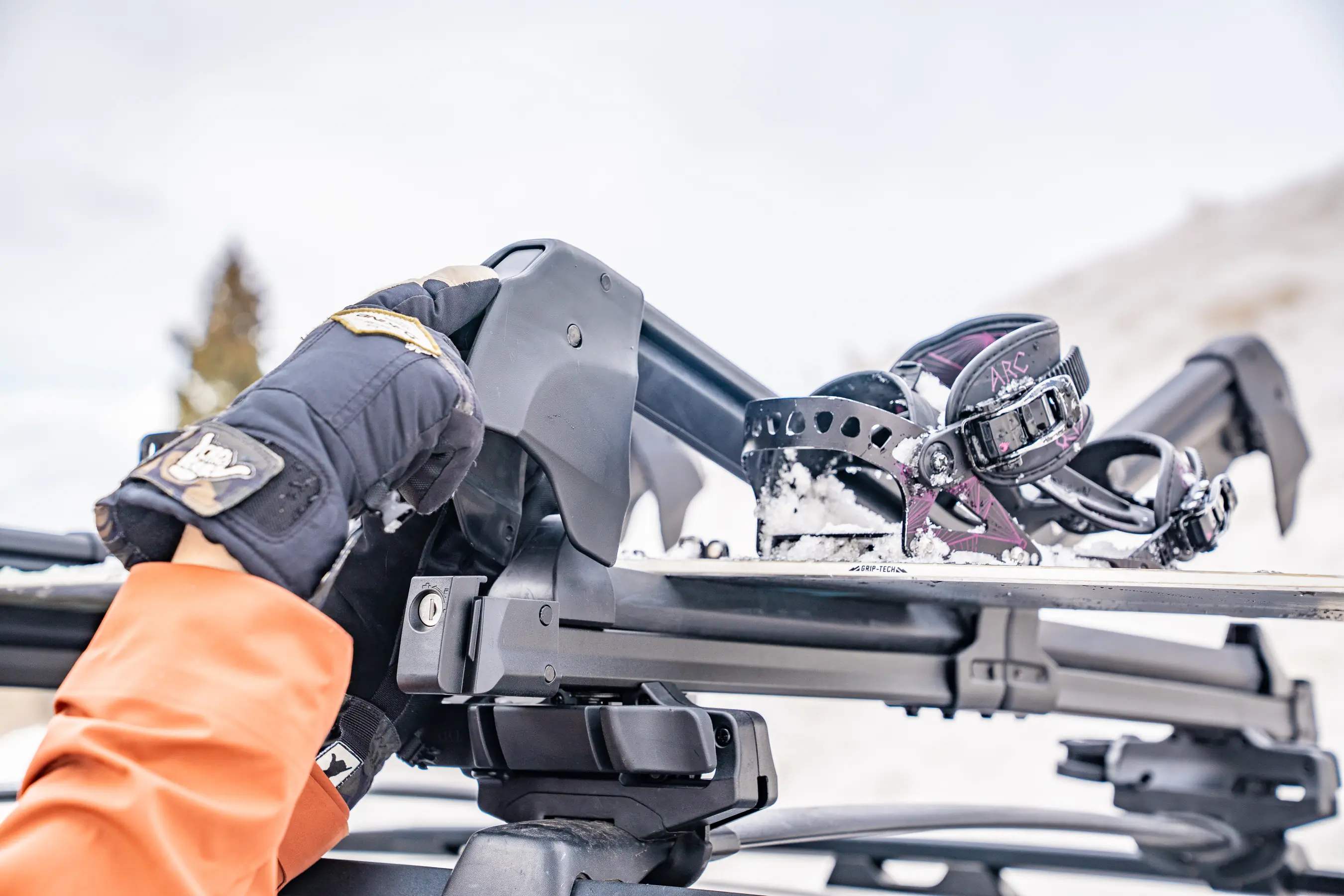Depending on the vehicle and person's height, reaching the arm on a roof rack can be hard once it swings open -- standing on the running board or door panel can help; (photo/Eric Phillips) 
