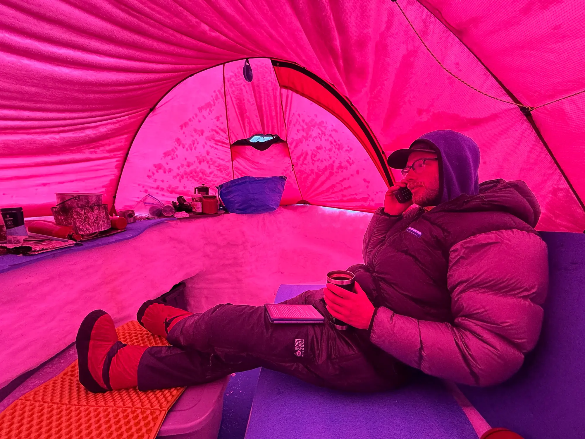 a climber makes a satellite phone call from his base camp tent in alaska