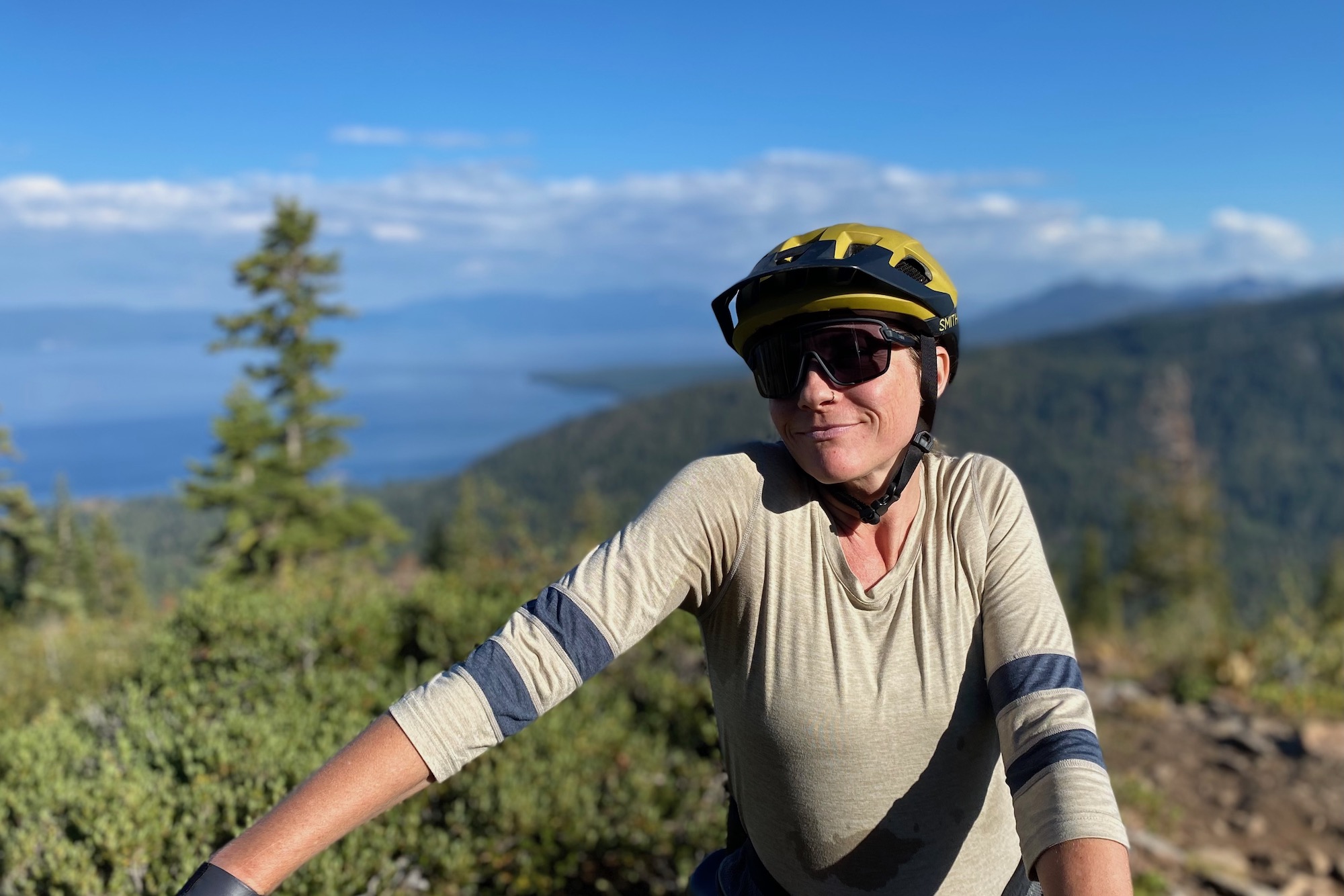 A female rider wearing the Smith Bobcat sunglasses with a bike helmet on a mountain bike ride.