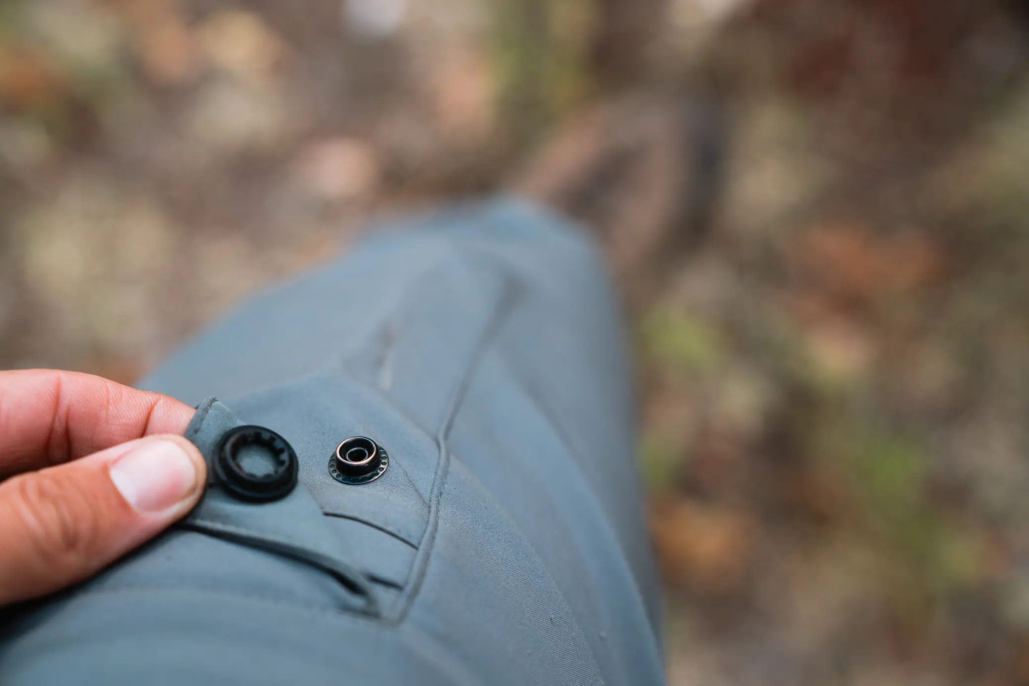 in focus man showing large pockets with quiet snaps on black ovis terrace pants