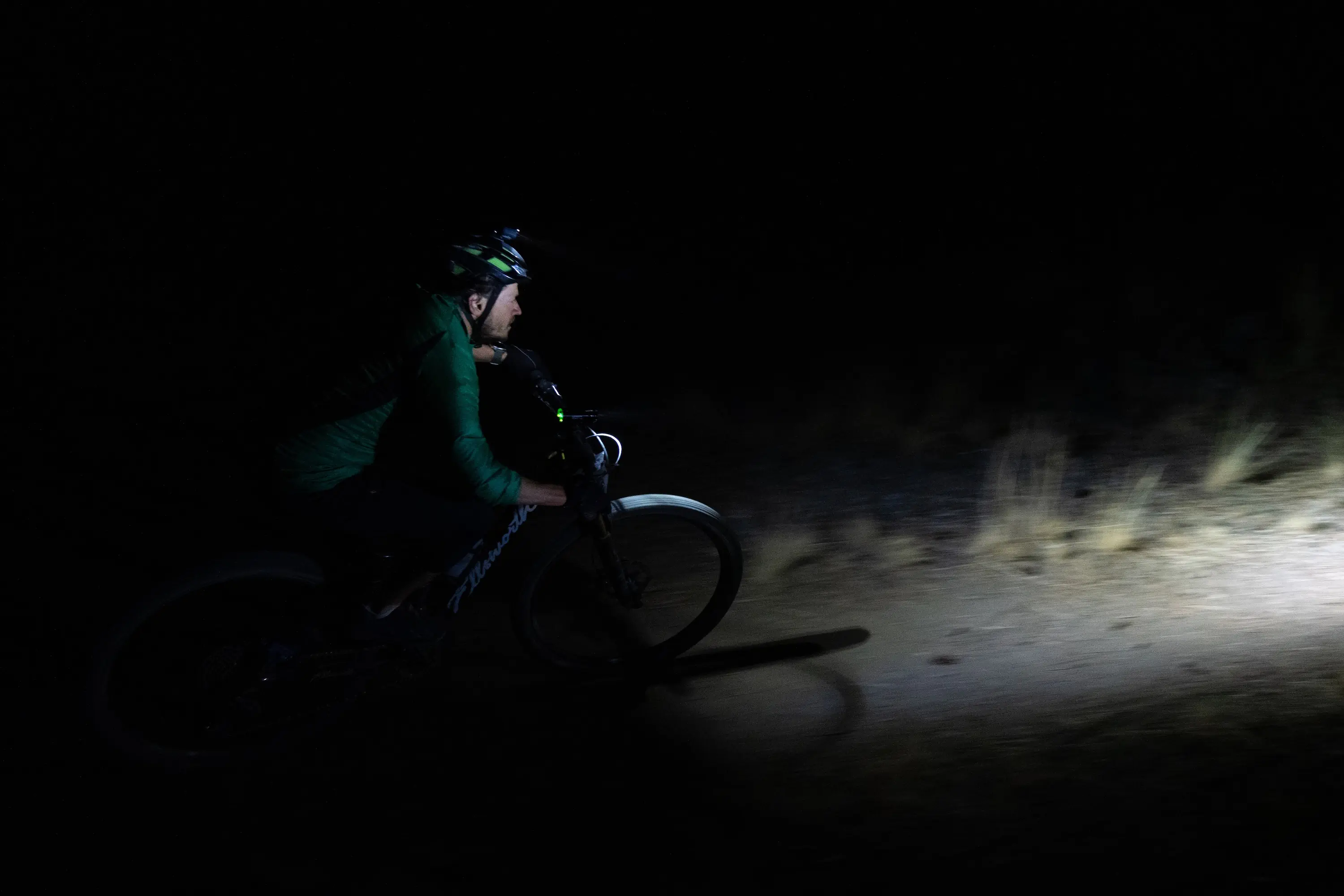 A mountain biker riding at night while testing mountain bike lights