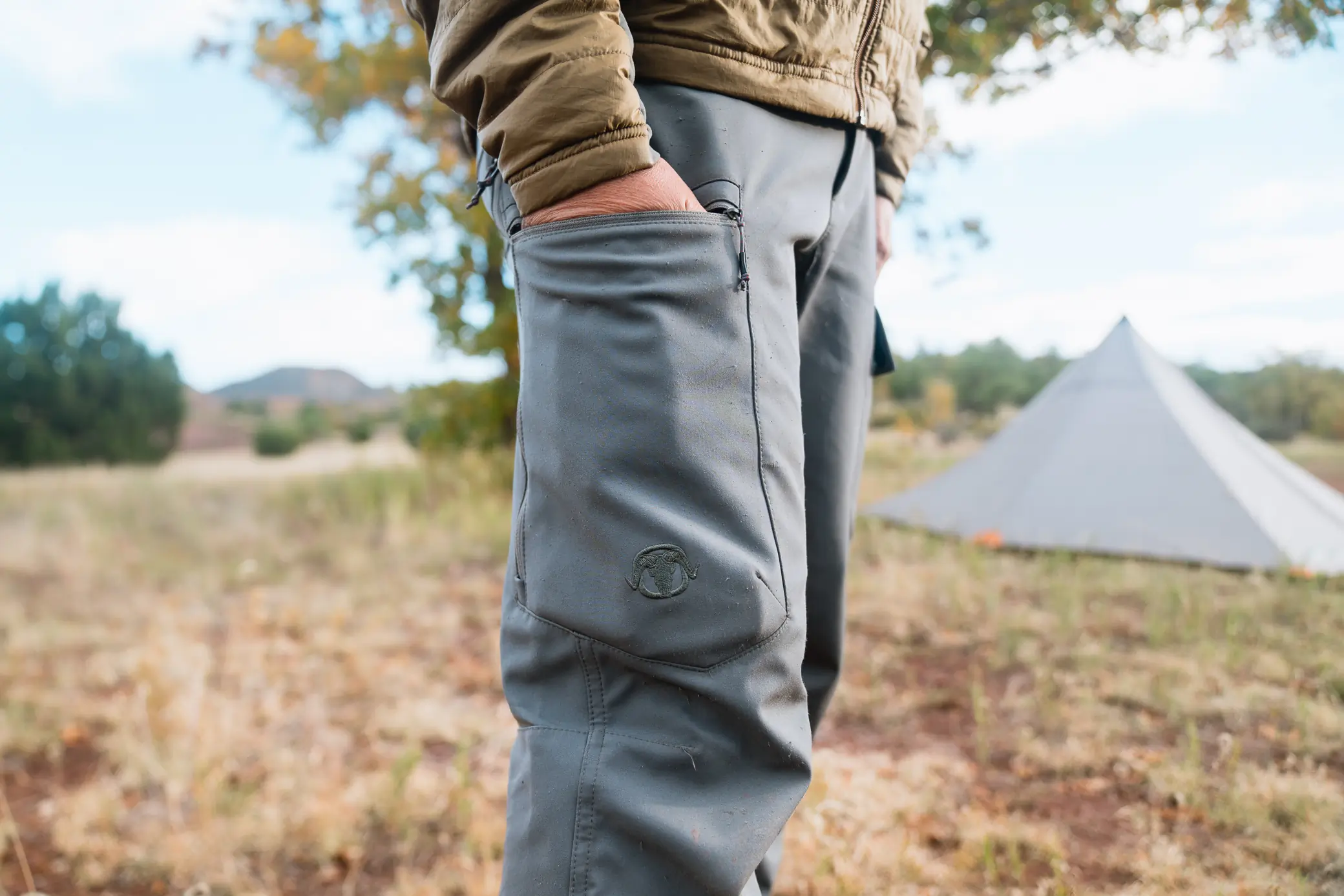 man holding hands inside large pockets on black ovis terrace pants 