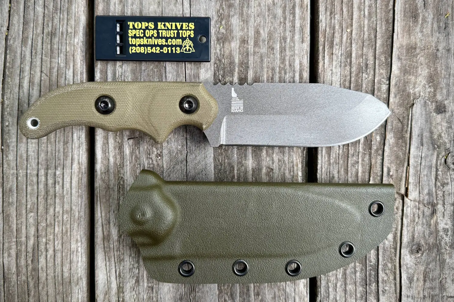 Wilderness Guide ‘23 knife with a tan handle next to its green sheath