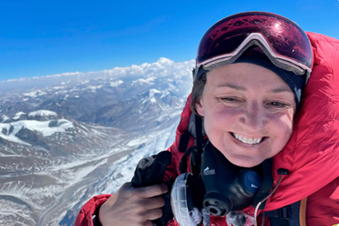 Tracee Metcalfe smiling on mountaontop
