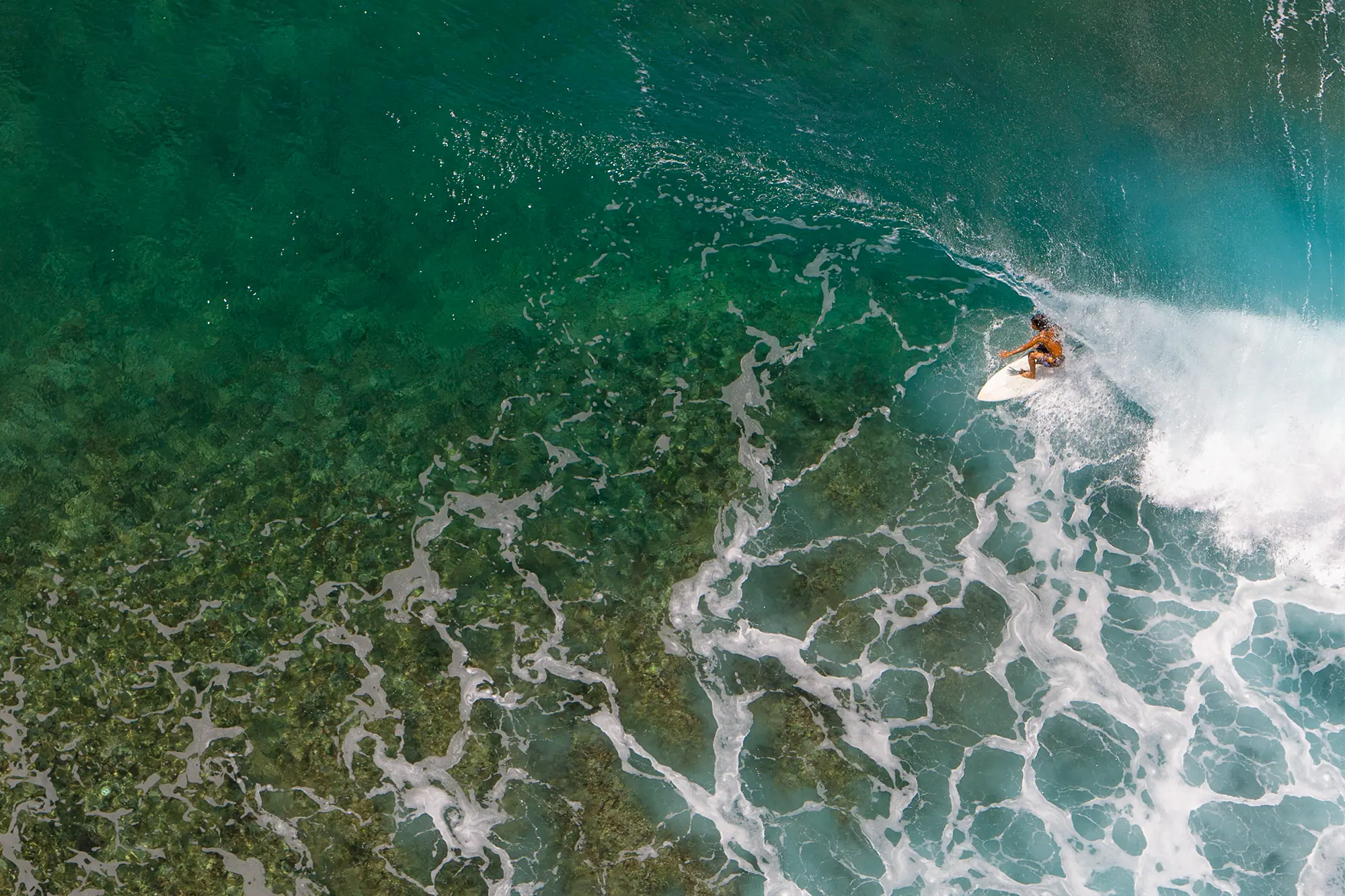 zoomed-out overhead photo of a person surfing