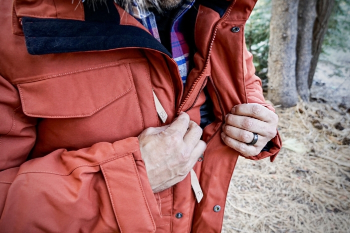 A man demonstrates one of the inner pockets on the Fjallraven Nuuk Parka.
