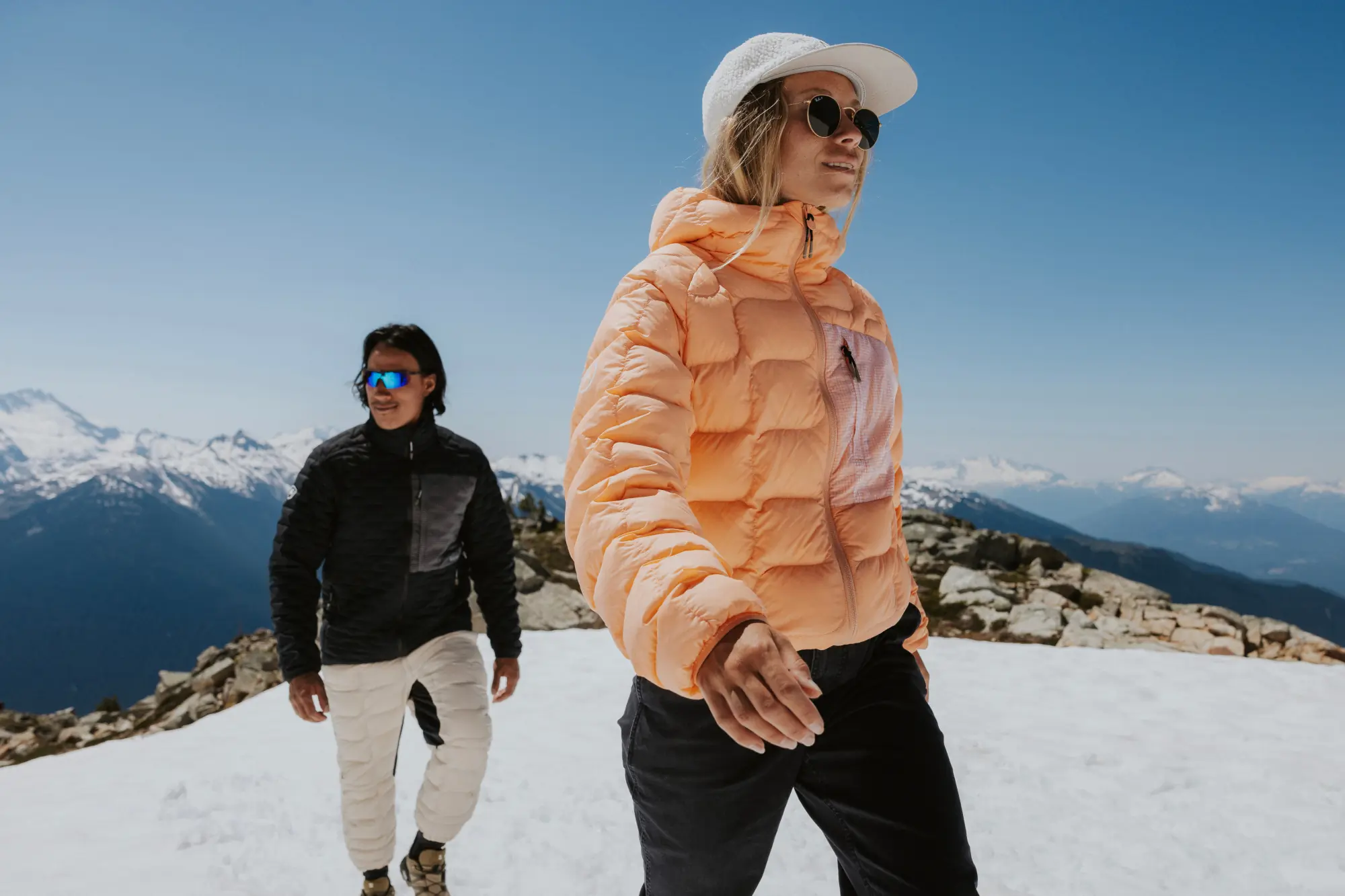 two people walking in snow on mountain