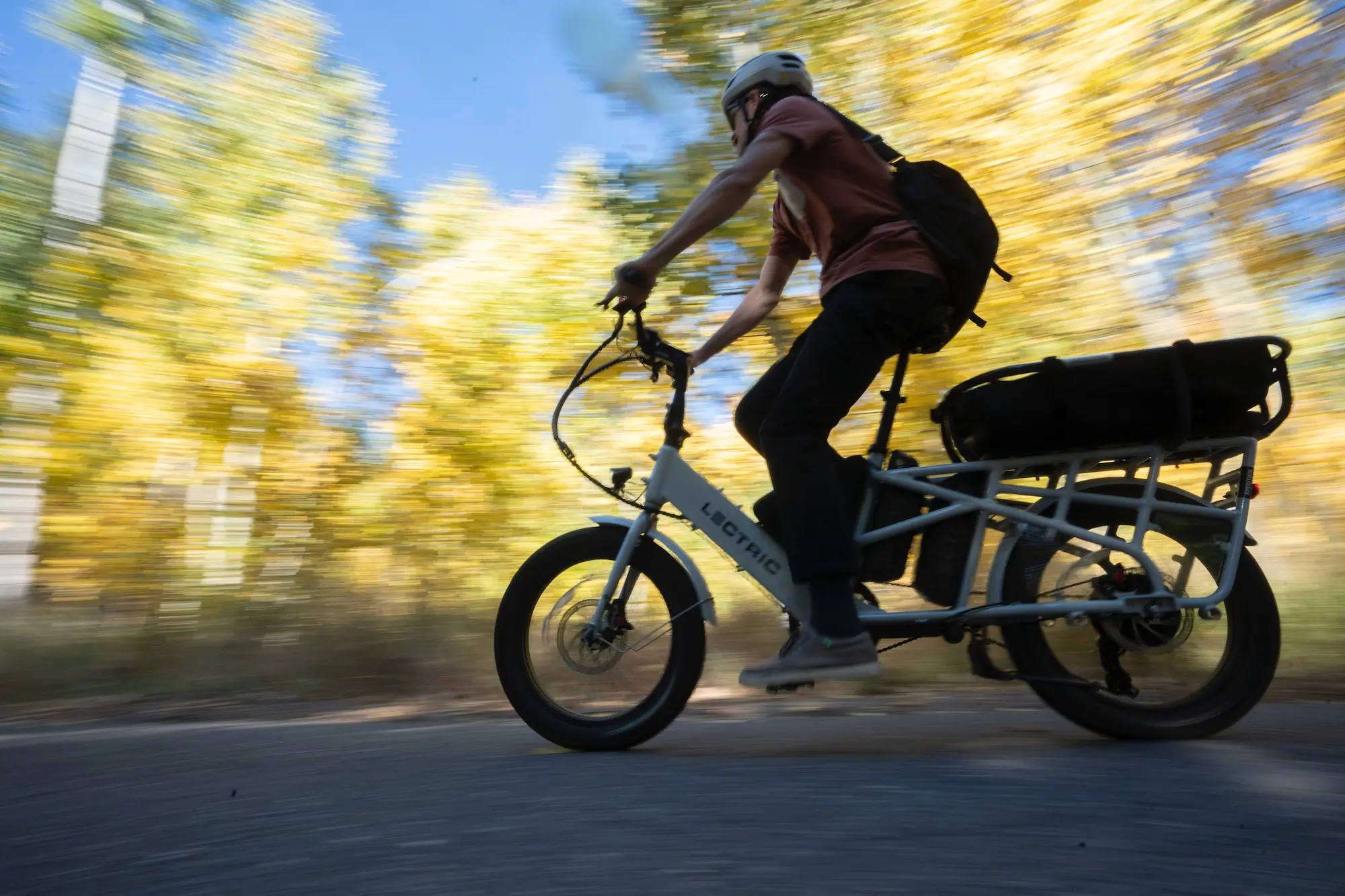Riding the Lectric XPedition electric cargo bike on path through some aspen trees with fall colors