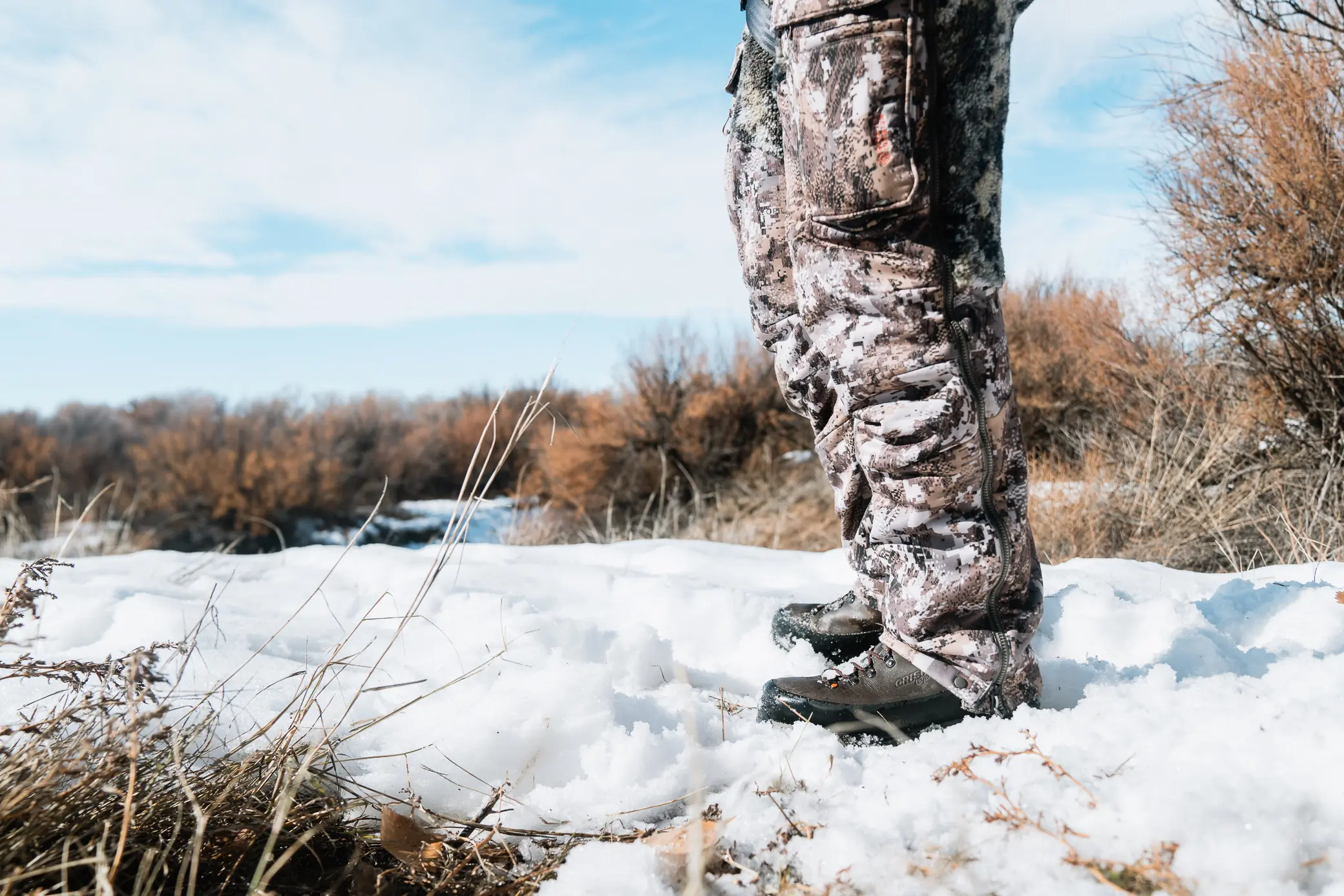 man wearing crispi wild rock plus gtx boots while standing on snow