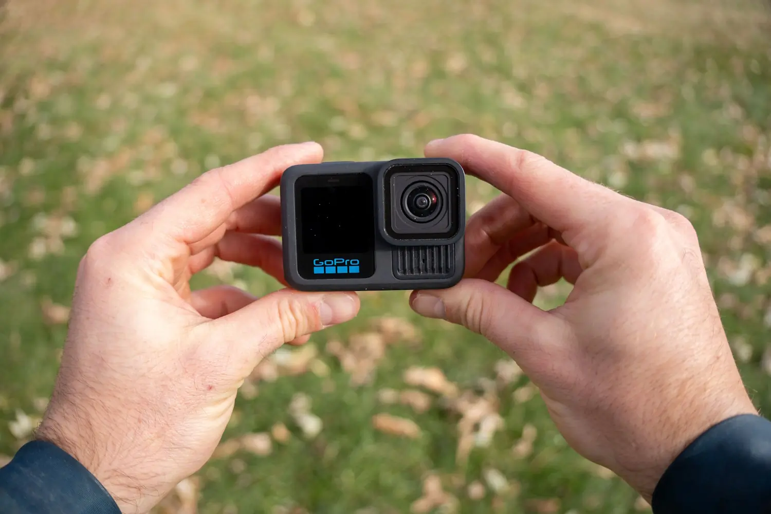 Hands holding a GoPro HERO13 camera outdoors