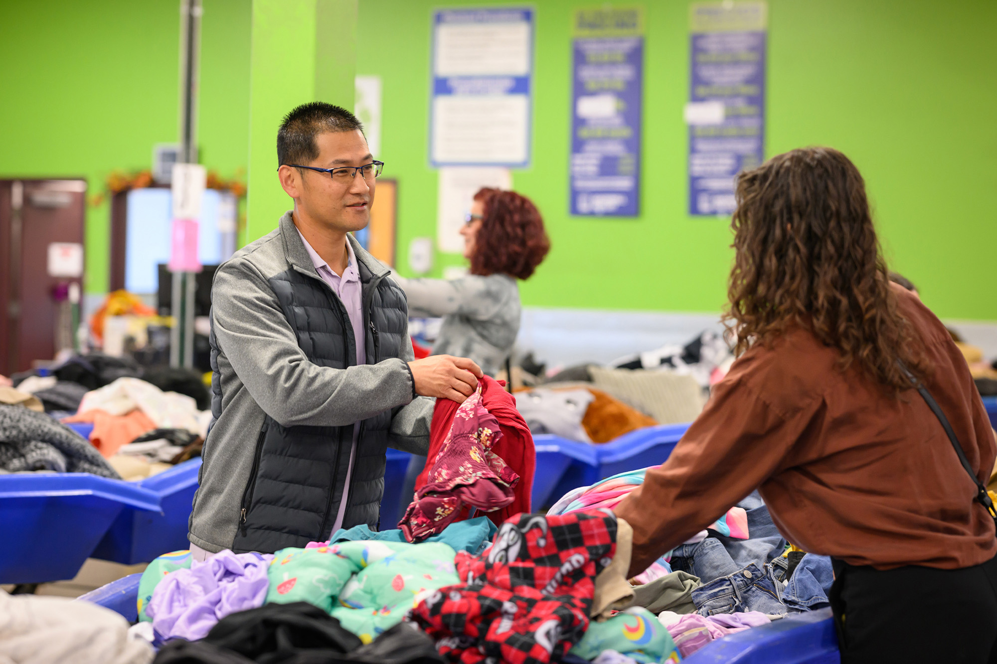 man handing woman clothes at textile outlet center