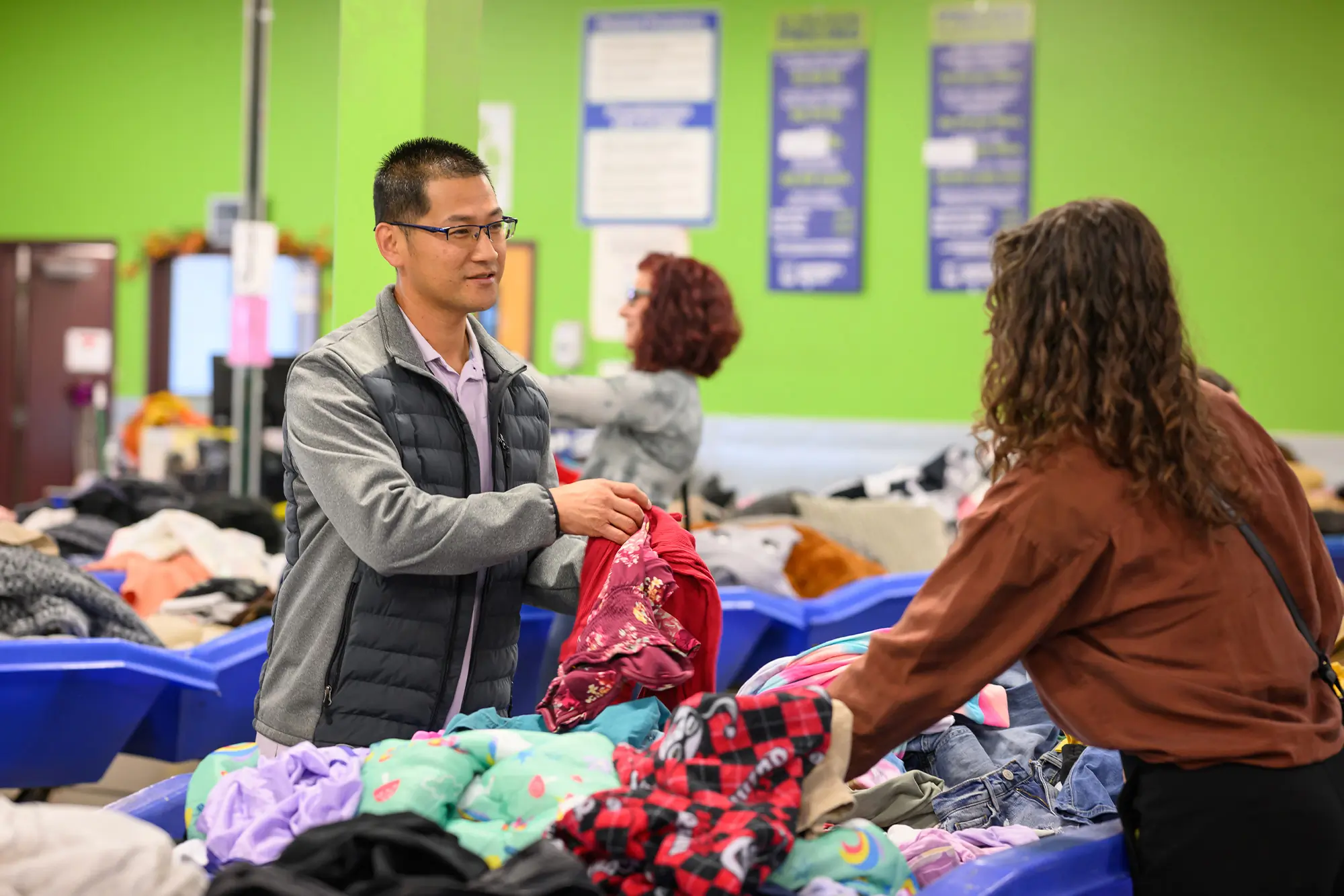 man handing woman clothes at textile outlet center