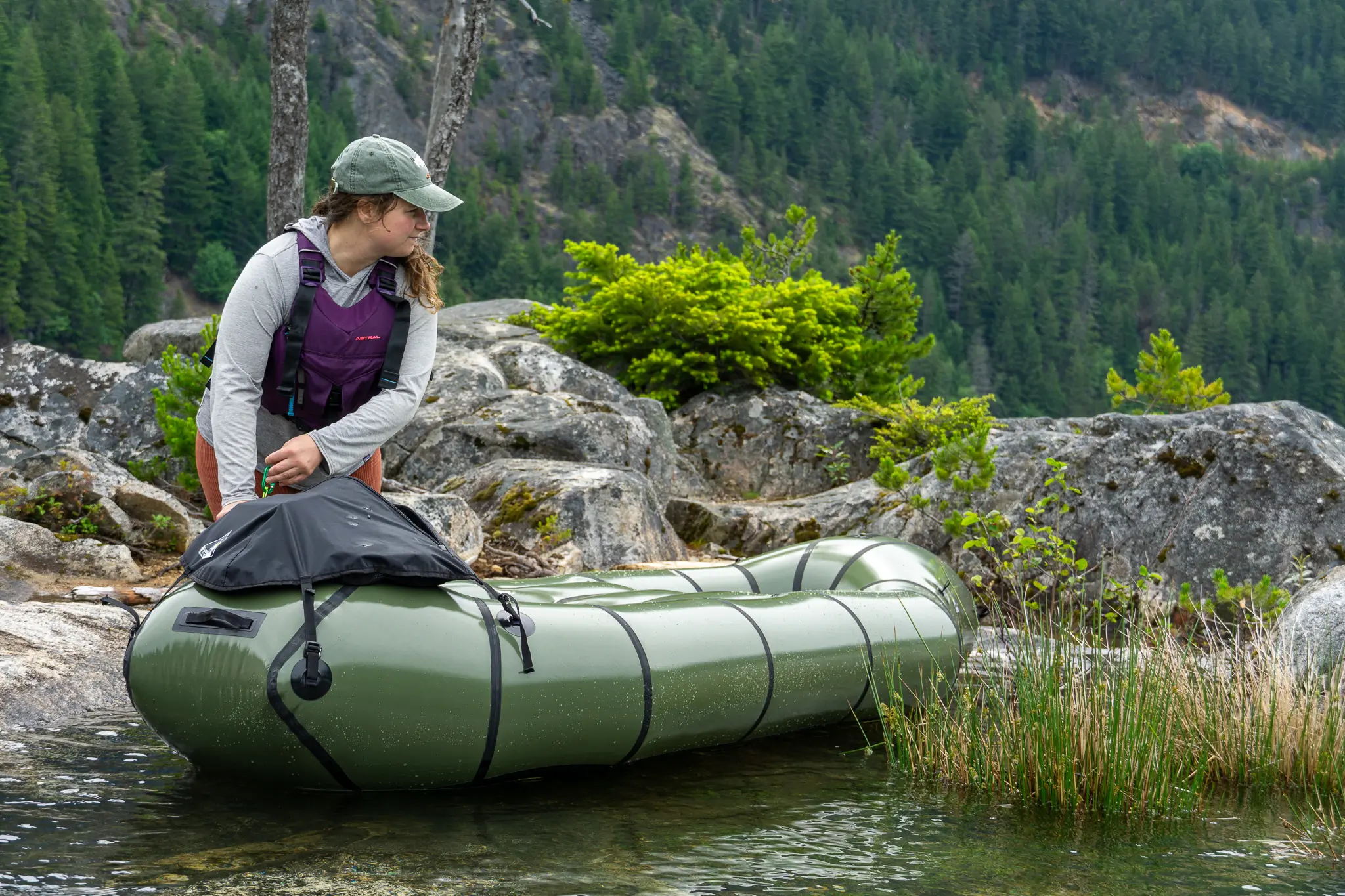 a woman in a purple pfd manages the rendezvous through a shallow section of water by walking it