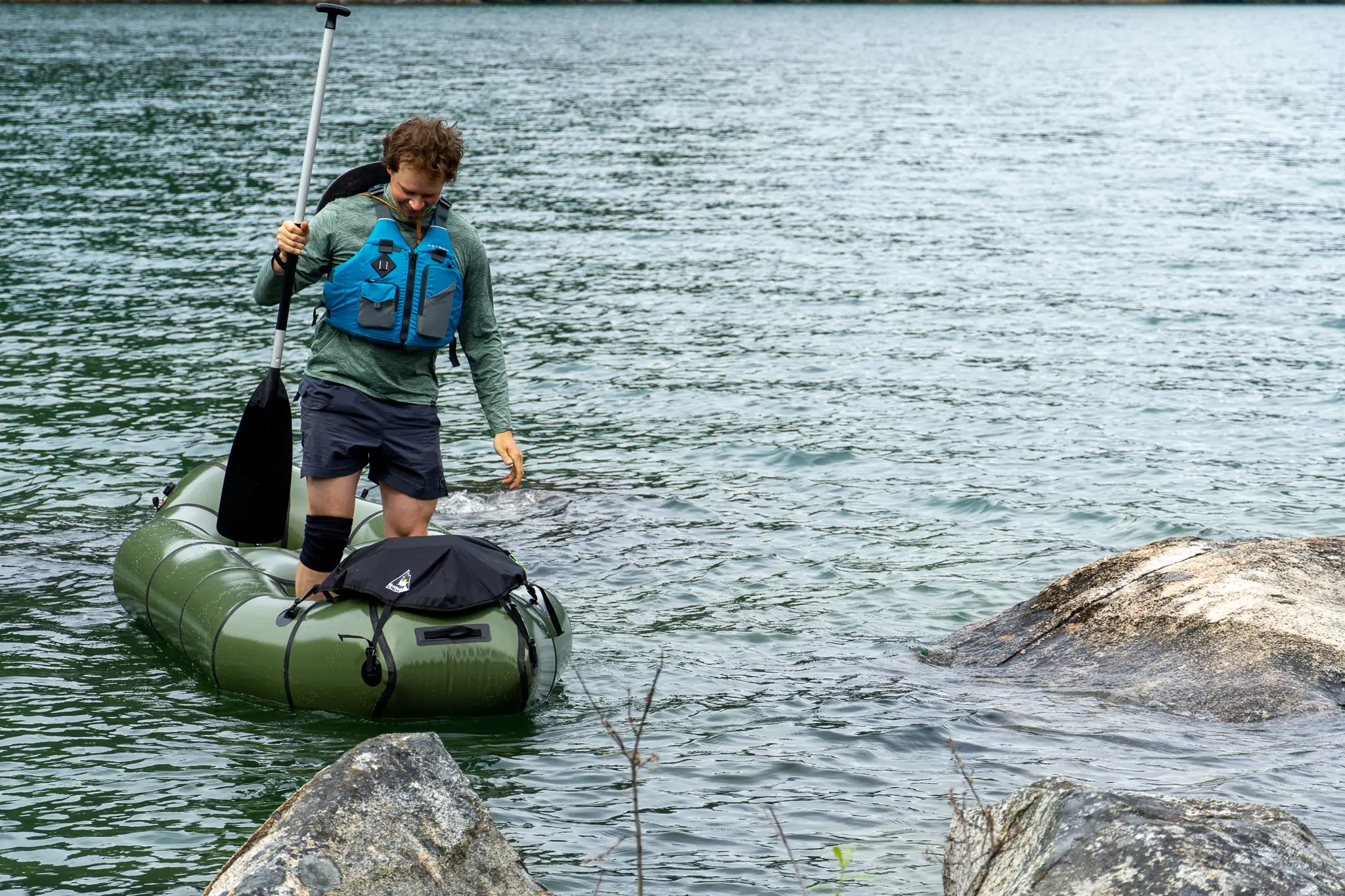 a solo paddler stands at the front of the rendezvous raft, exhibiting the stability