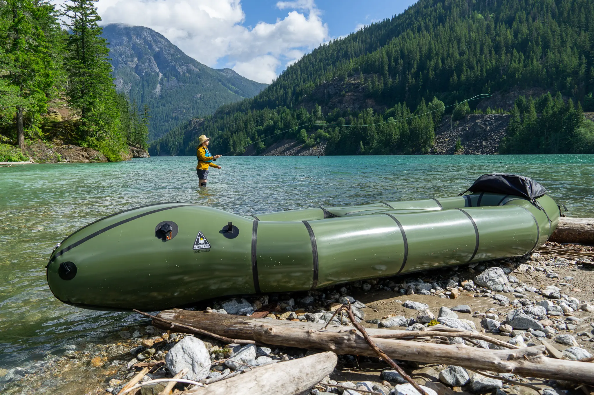 a fisherman makes casts in the background, with the rendezvous raft in the foreground