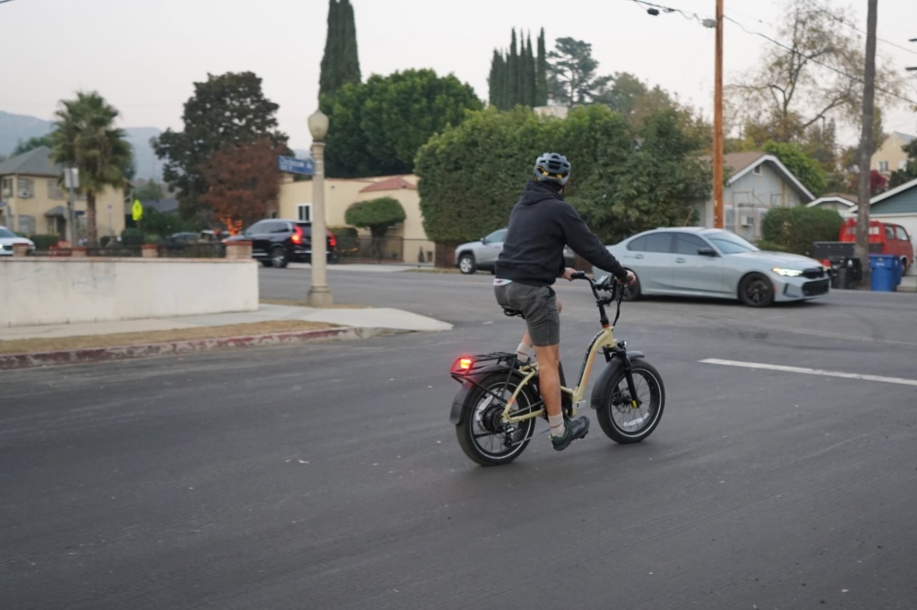 Riding the Rad Power RadExpand 5 Plus folding electric bike on a city street.