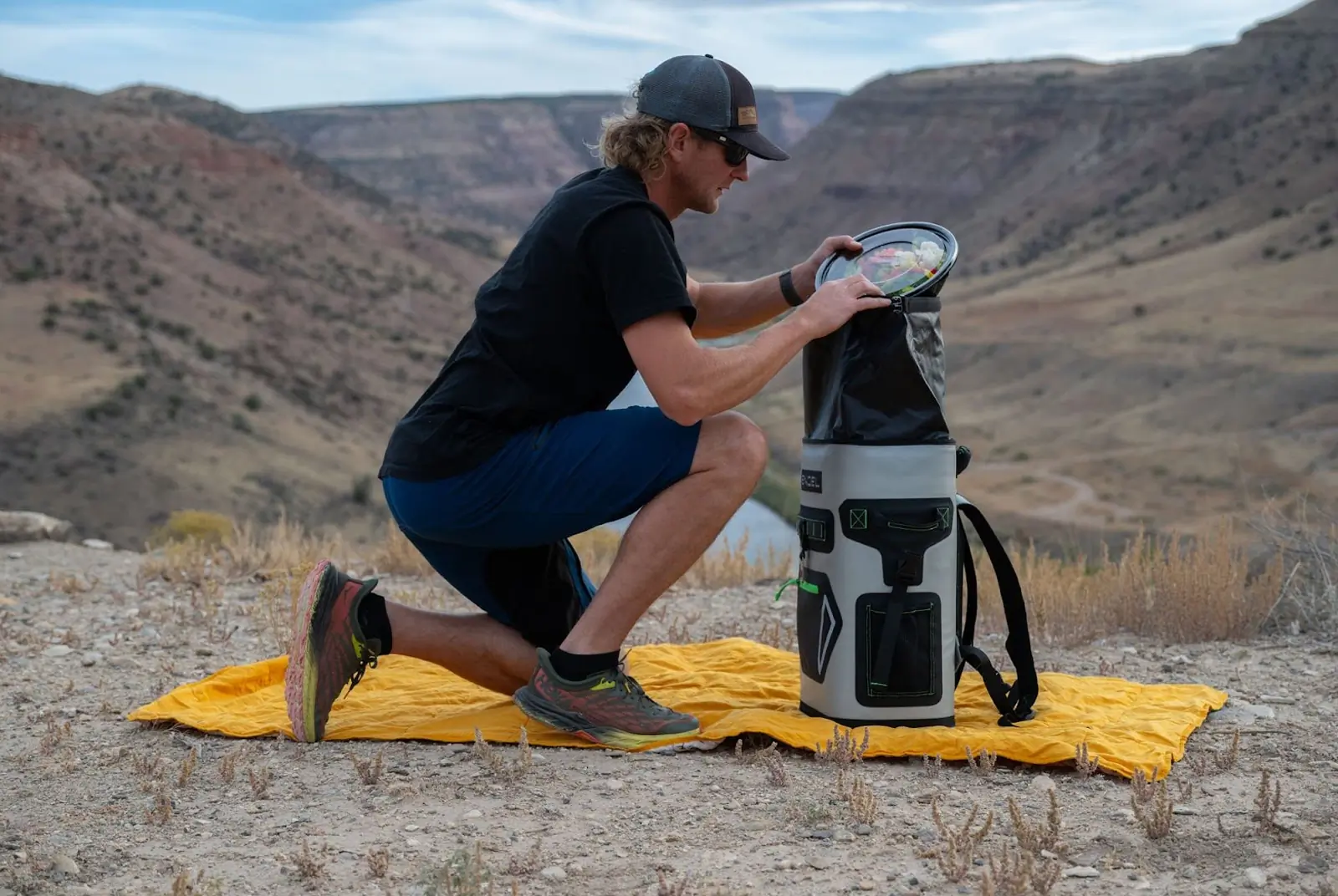 man opening Roll-top Closure on Engel Roll Top High Performance Backpack Cooler