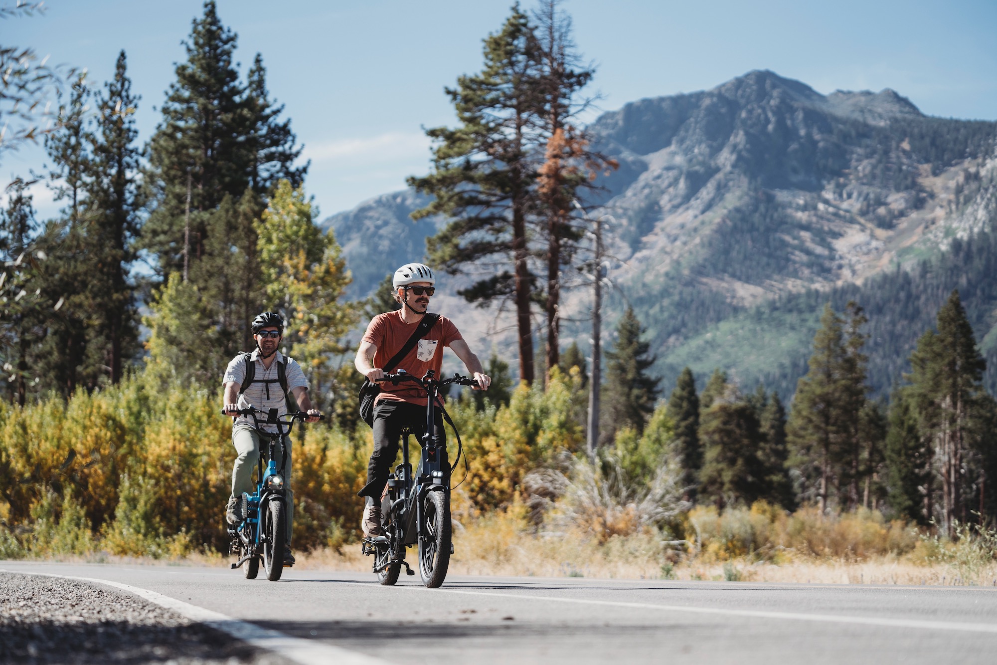 Testing the ENGWE LE20 while riding on a paved bike path with a mountain in the background