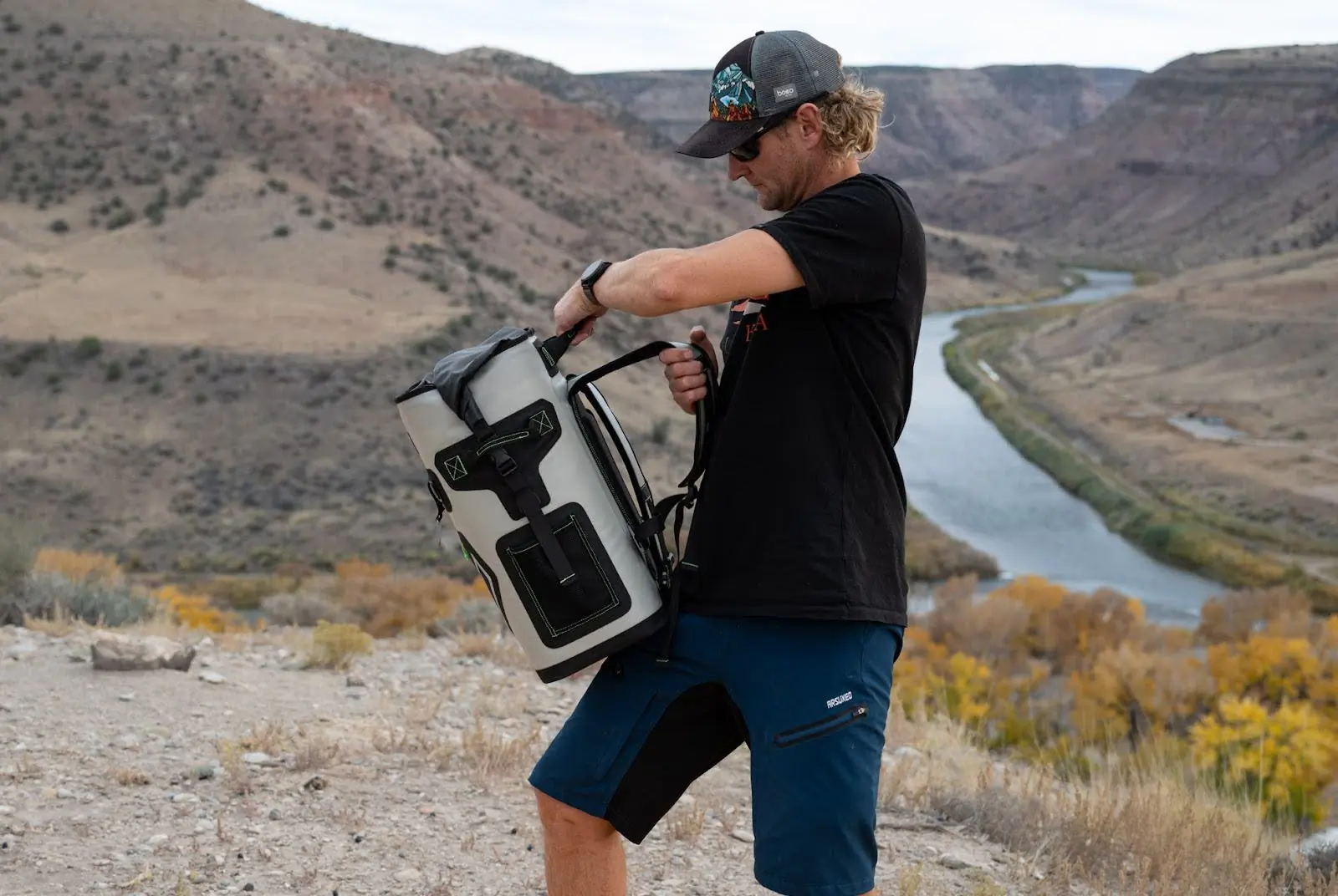 man holding engel roll top high performance backpack cooler