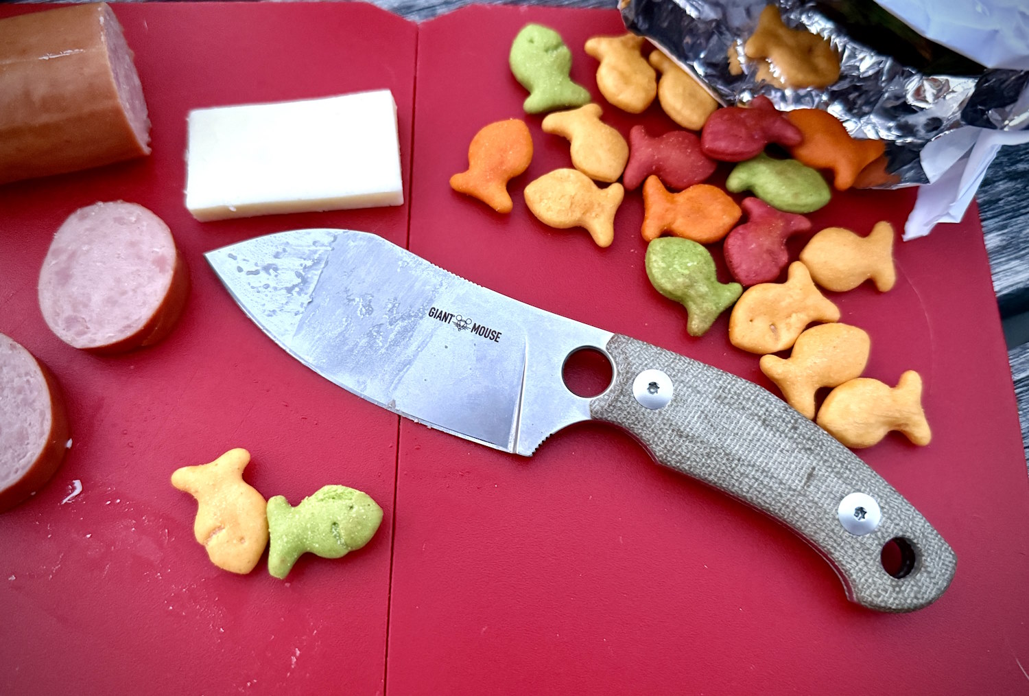 Knife surrounded by snacks on a red board