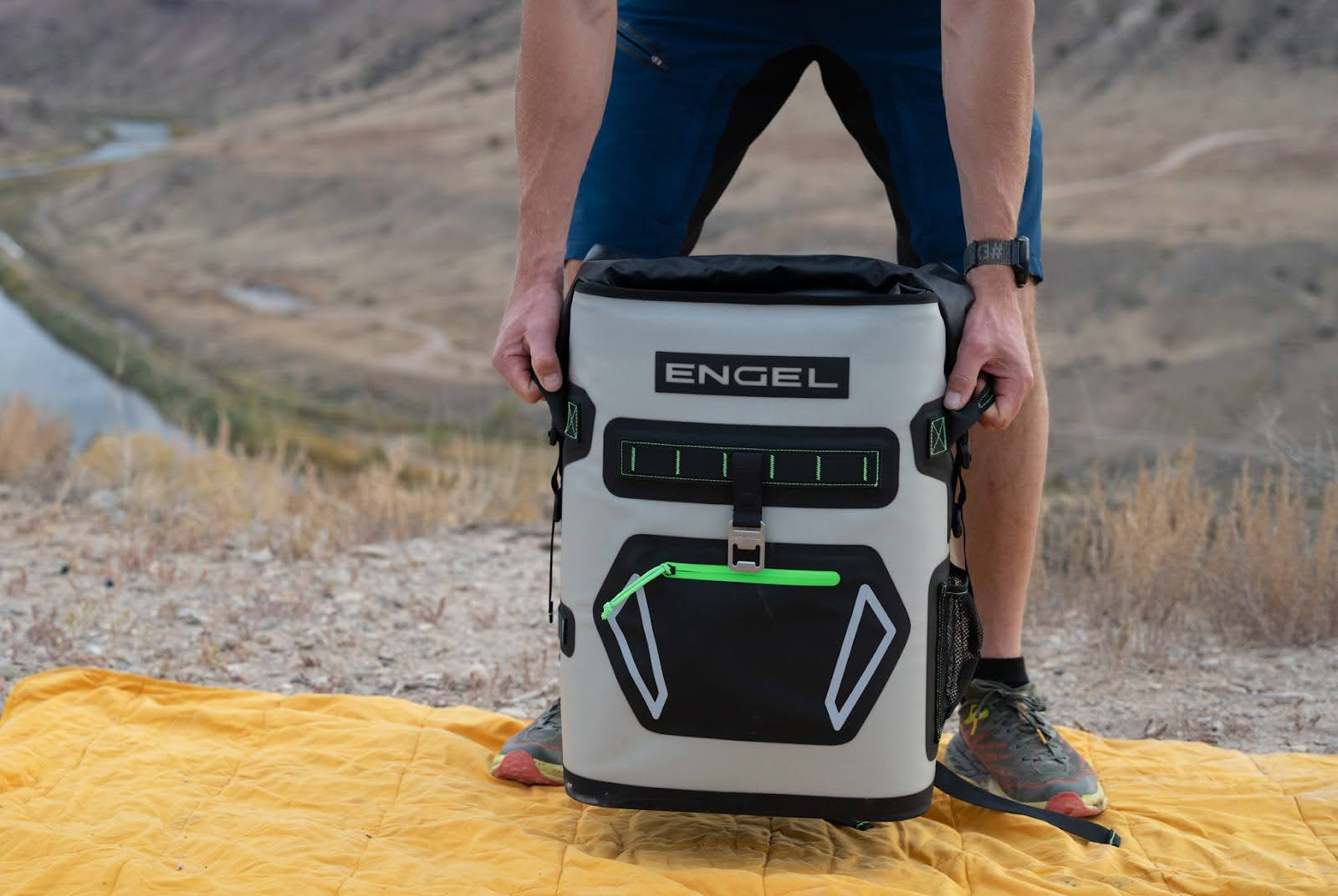 man holding the engel roll top high performance backpack cooler