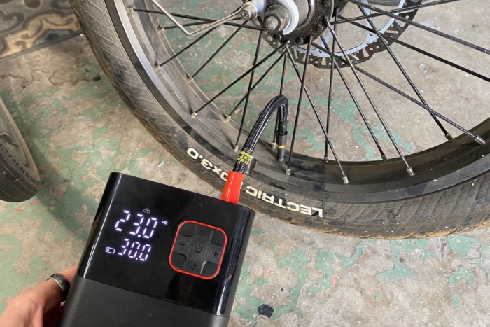 Using the Kohree Portable Tire Inflator to pump up a bike tire