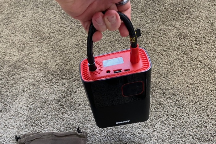 Carrying the Kohree Portable Tire Inflator using the thread-on hose as a handle